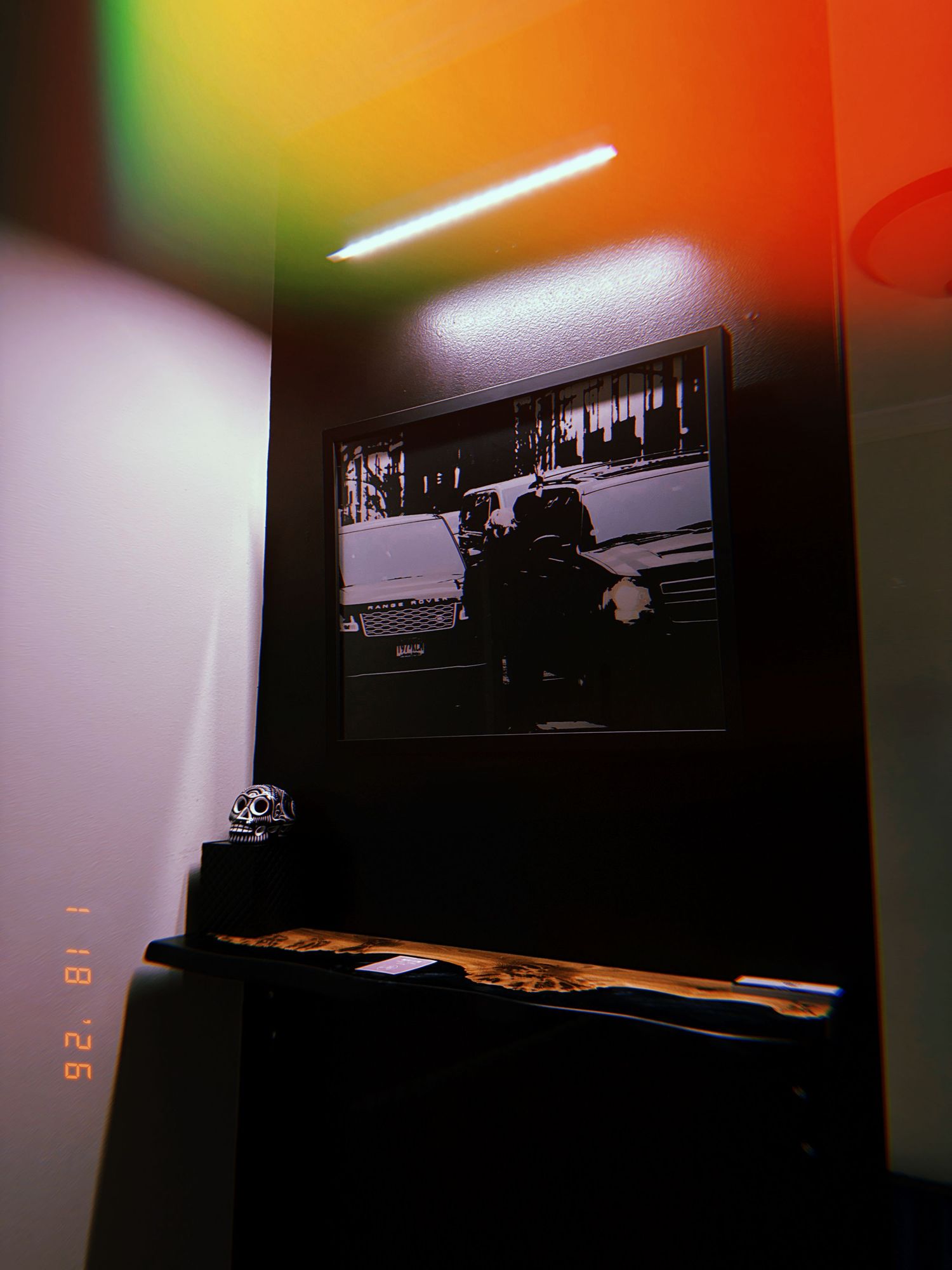 A black and white photograph displayed on a dark surface with colorful ambient lighting effects in the background.