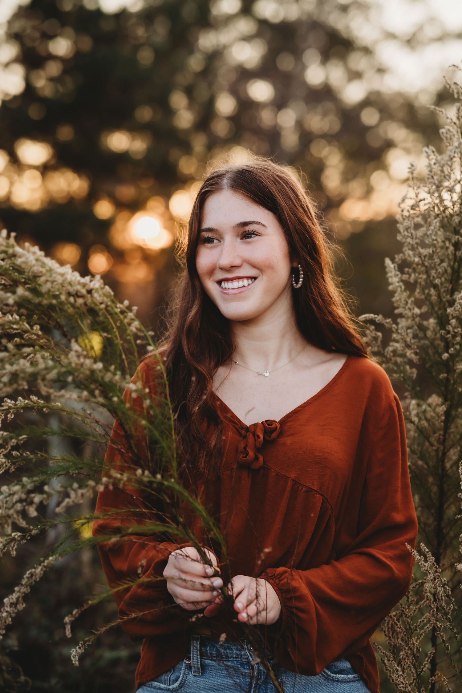 A golden hour portrait in a field with rustic autumn fashion and natural foliage.
