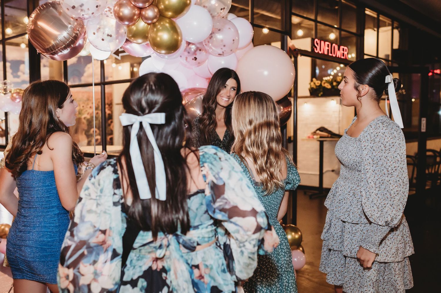 Party celebration with gold and pink balloons creating festive atmosphere indoors.