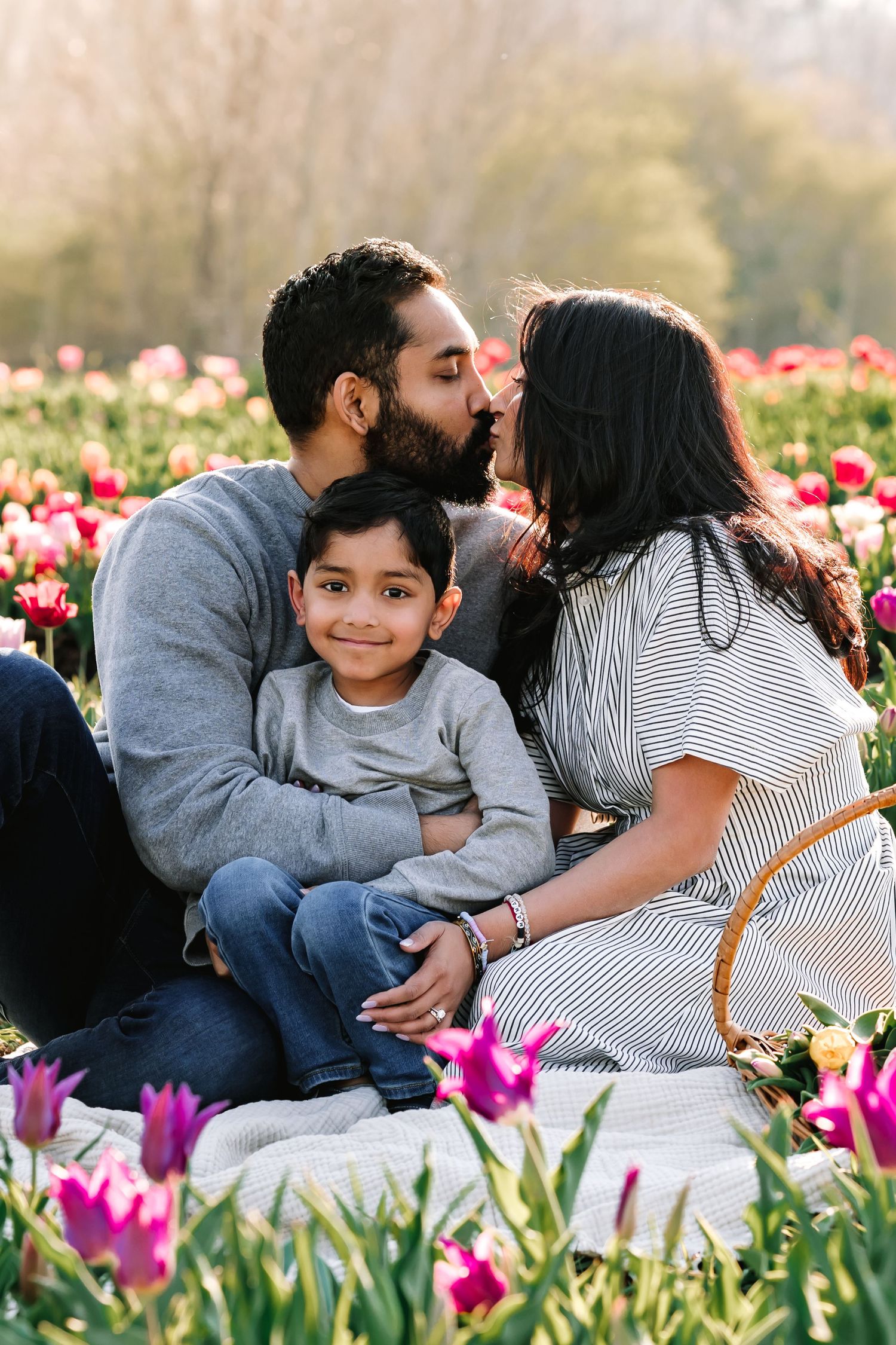 A family shares an intimate moment among blooming spring tulips.