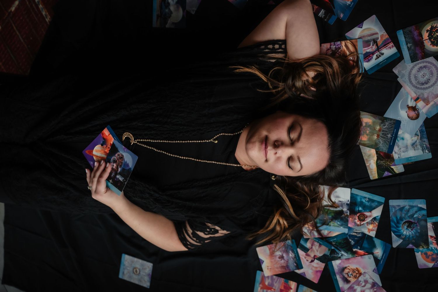Creative portrait with polaroid photos scattered on dark background.