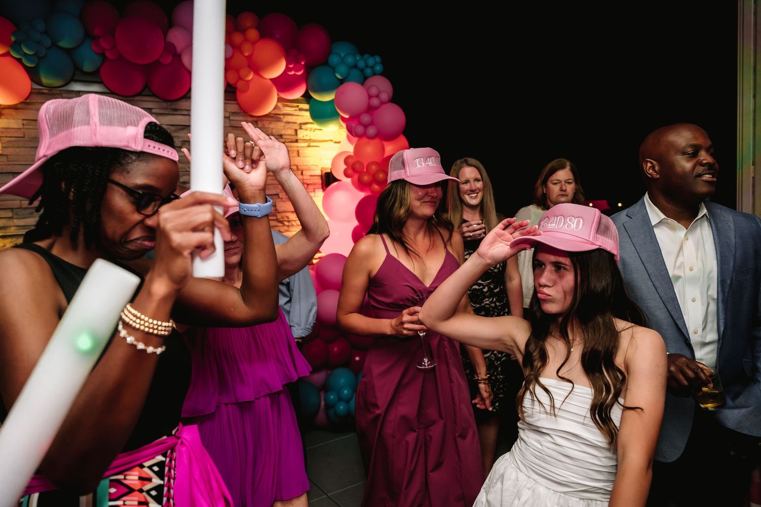 Wedding reception dance floor scene with colorful lighting and festive atmosphere.