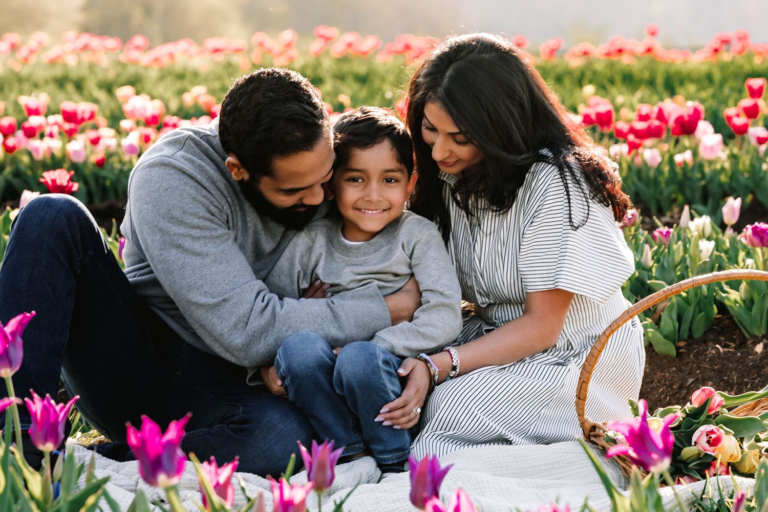 A loving family shares a tender moment together in a vibrant tulip field.