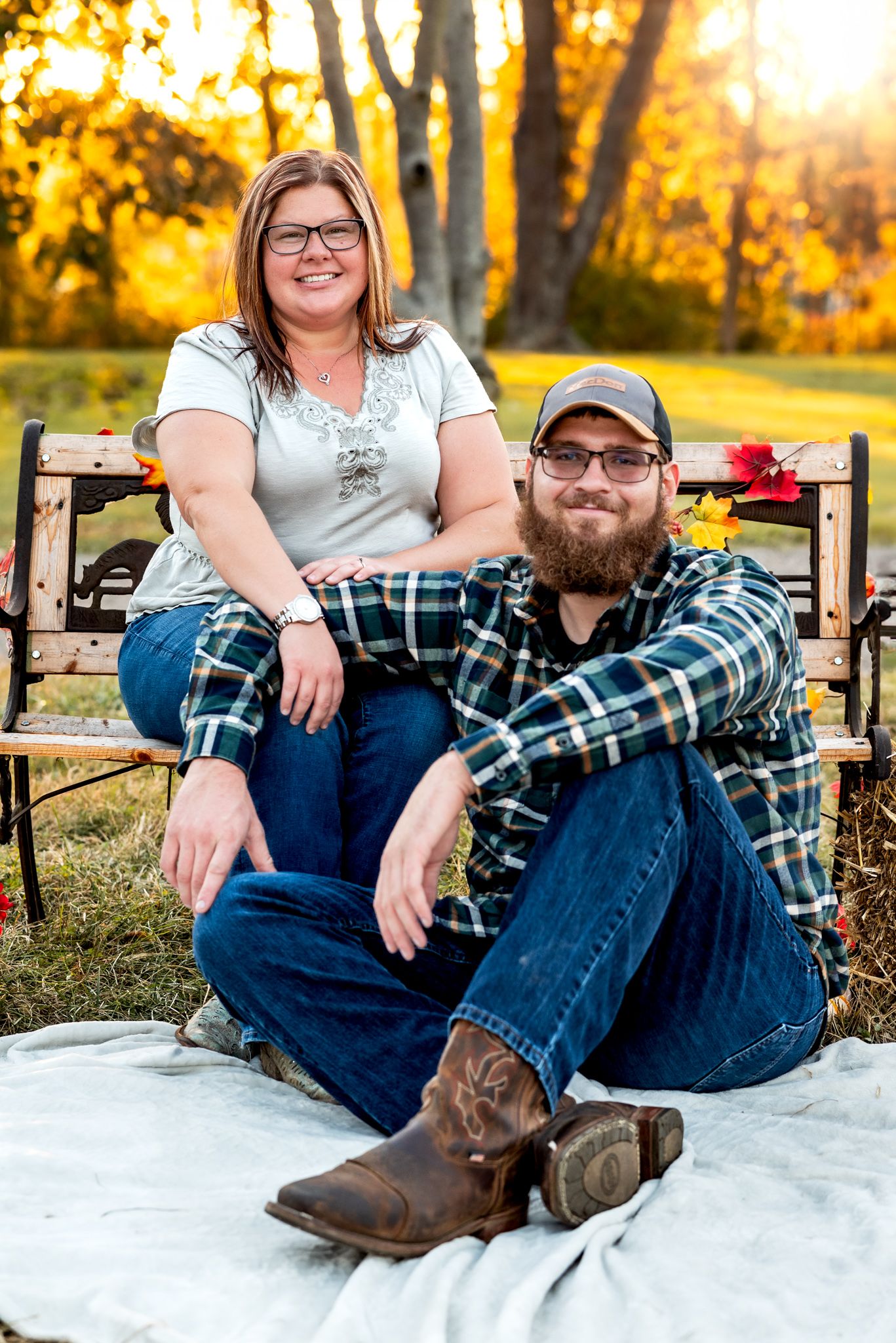 A casual autumn portrait on a blanket featuring plaid shirt and boots in golden sunlight.