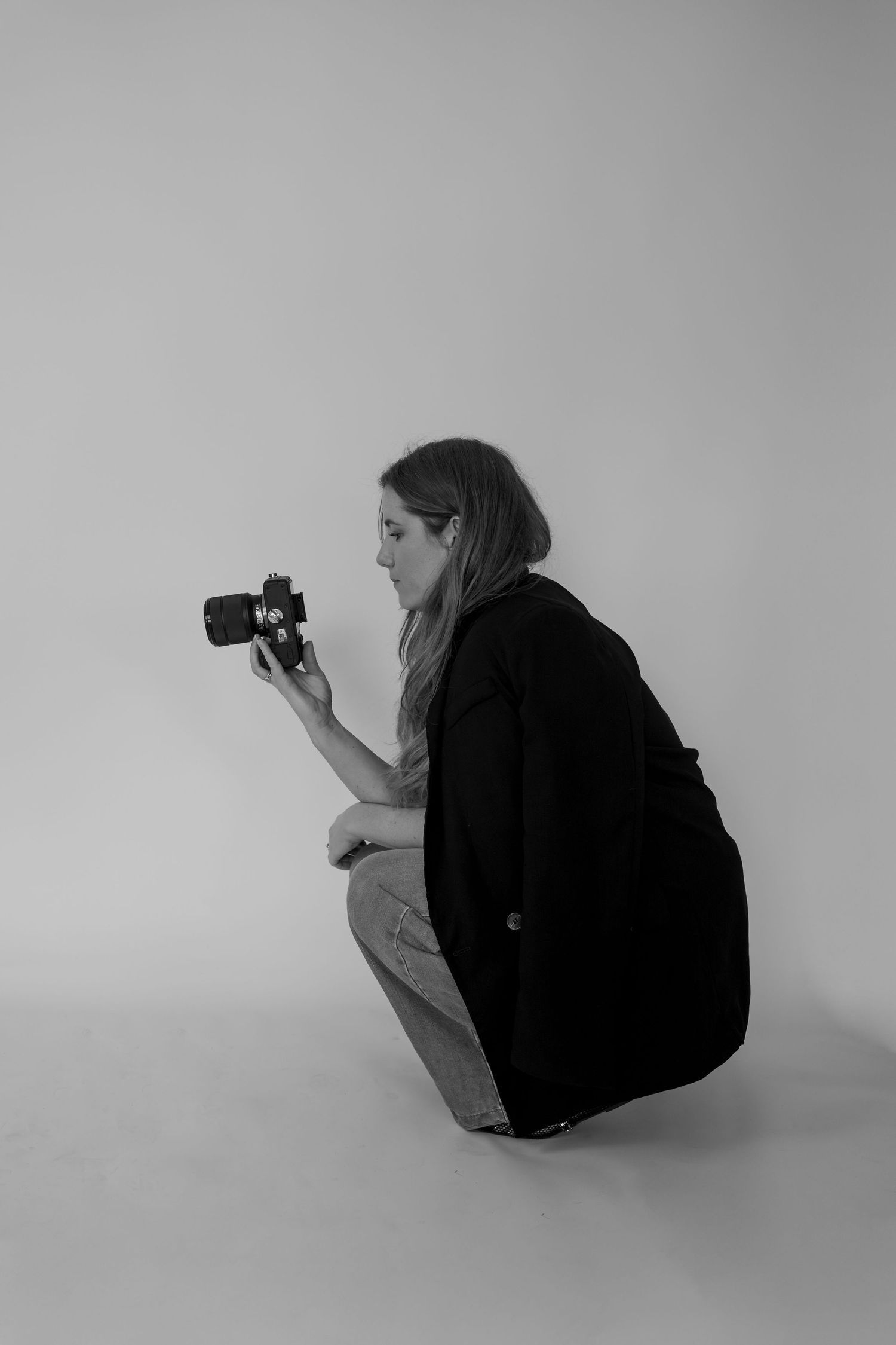 A series of black and white photos showing a photographer crouching in different positions while taking pictures.
