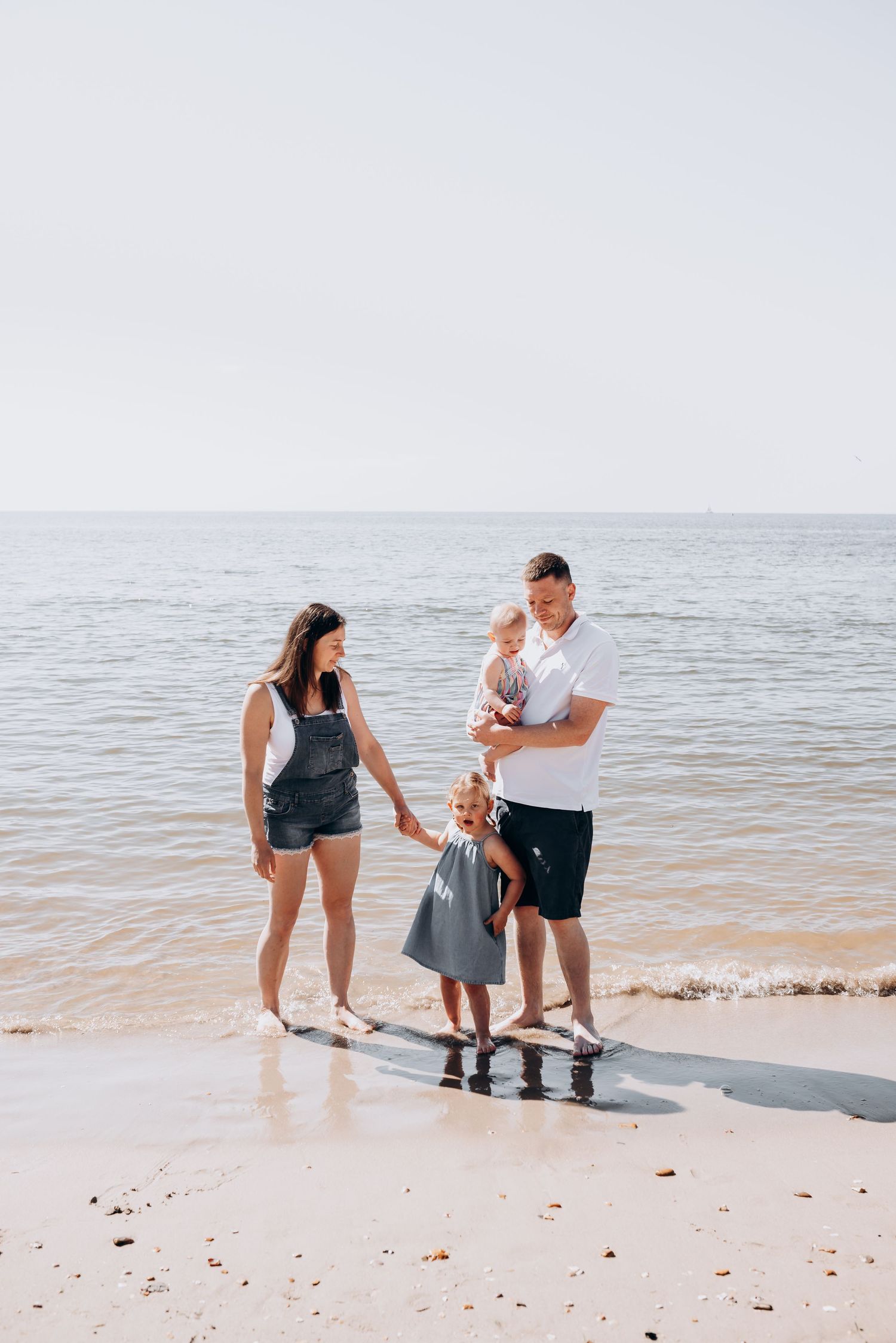 Family enjoying time together on a sandy beach by the ocean.