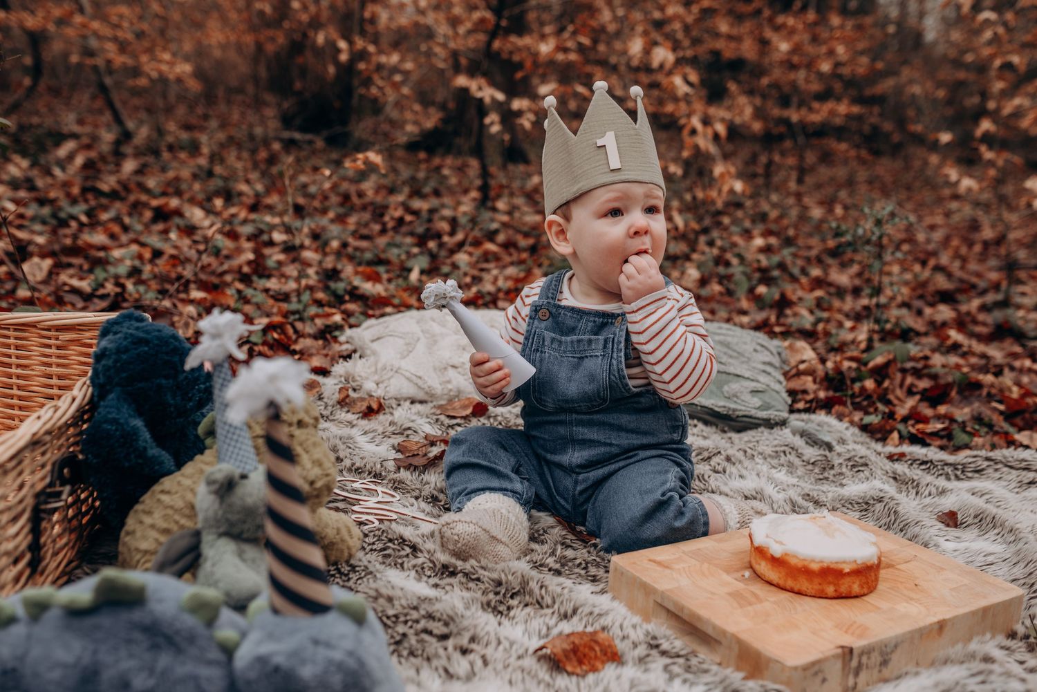 Outdoor autumn scene with blanket and decorative setup for cake smash photography.