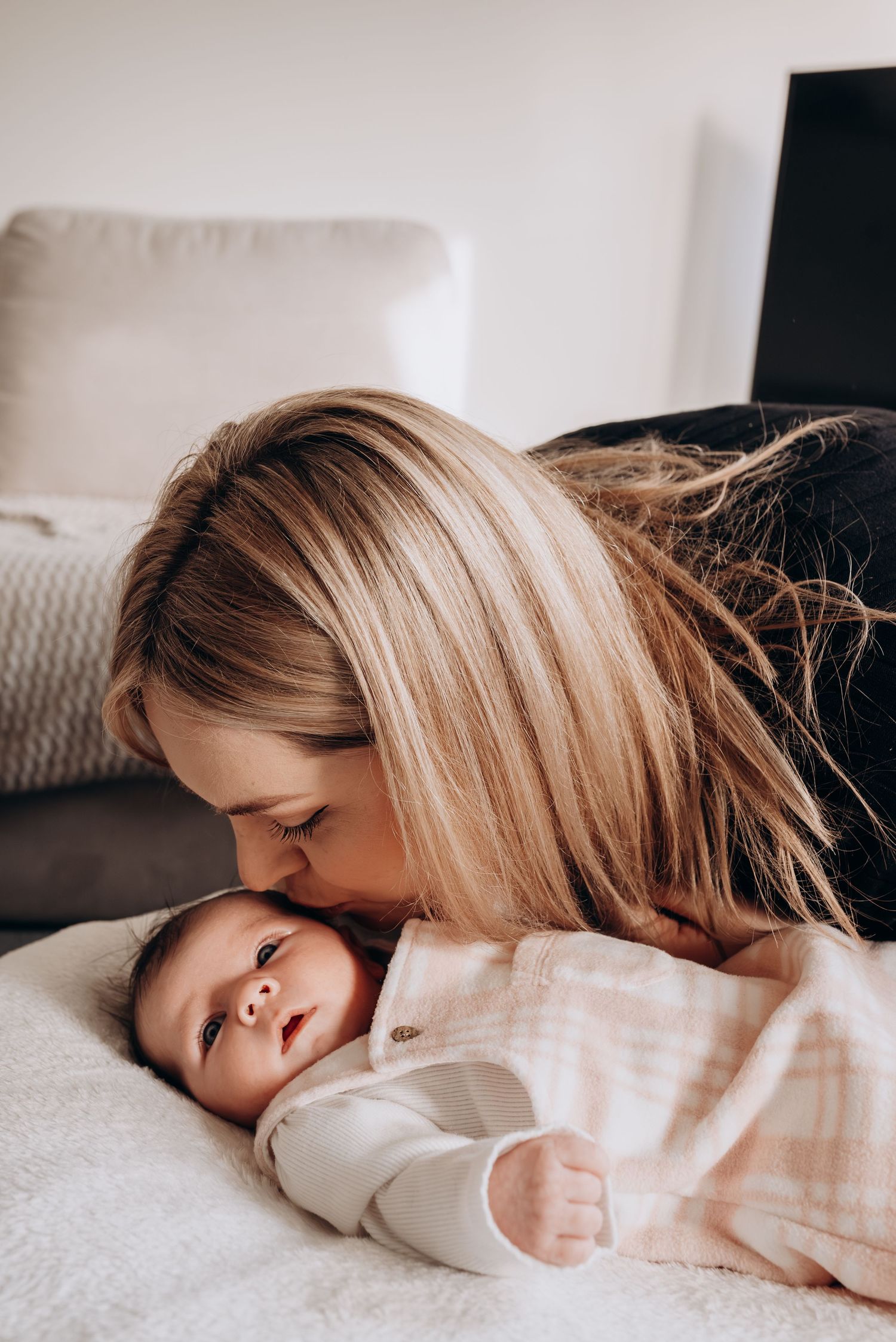 Intimate close-up shots of mother and child sharing tender moments while lying down together.