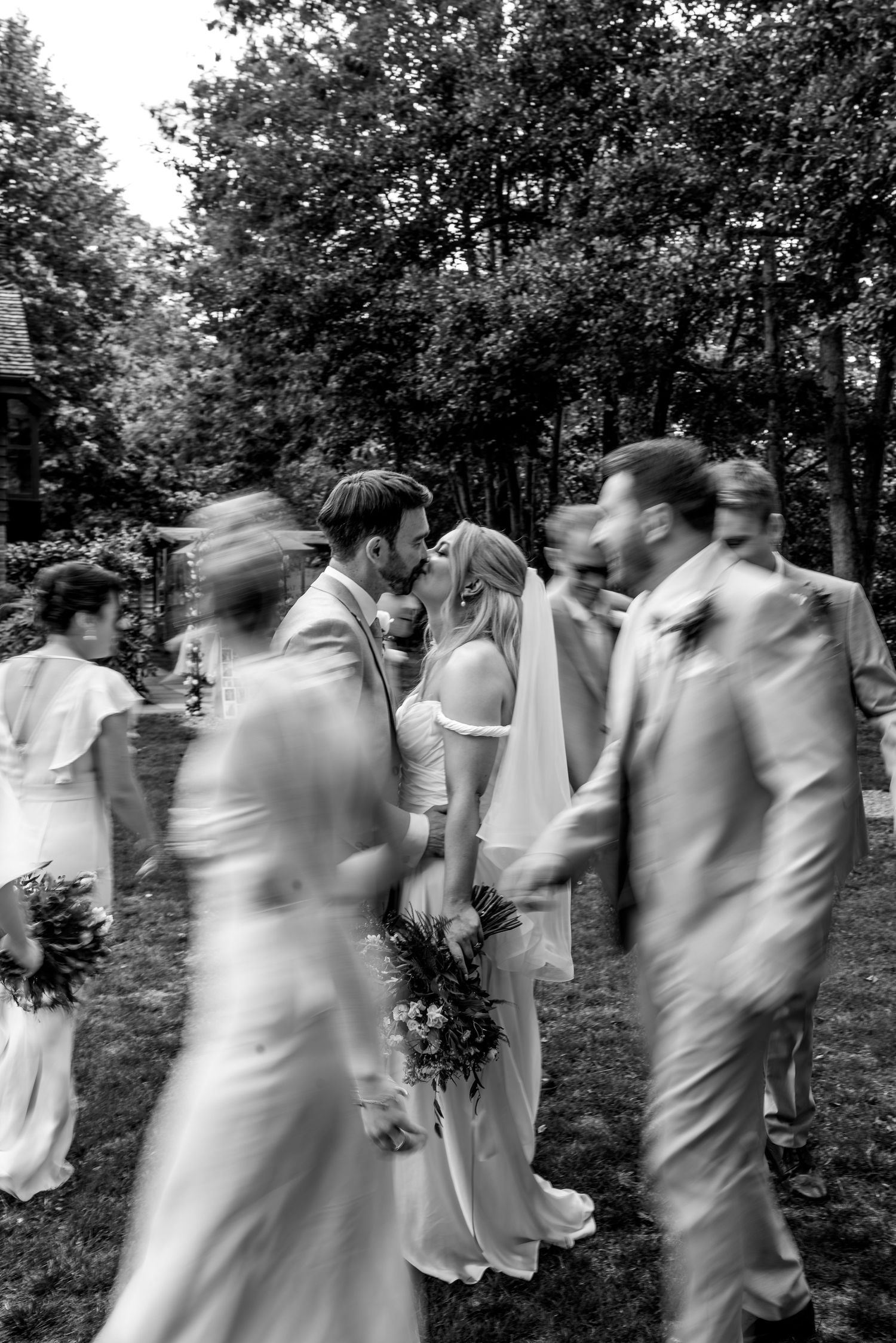 A sequence of black and white photos showing people dancing and twirling in an outdoor garden setting.