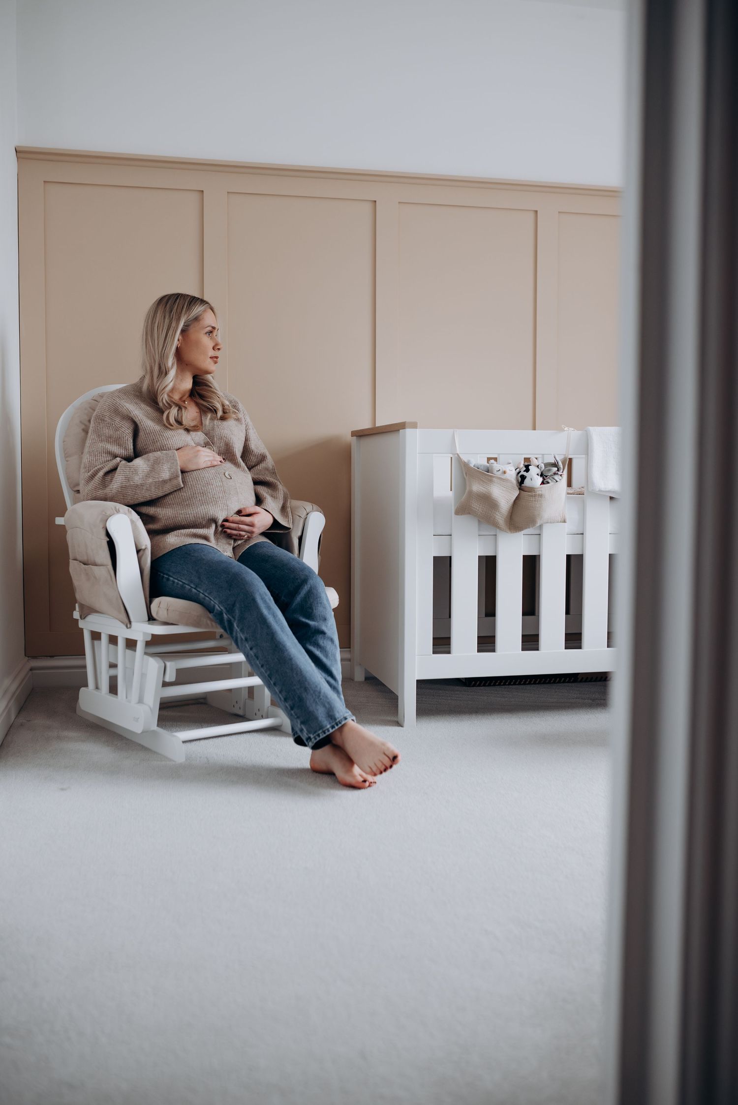 A relaxed maternity session in a nursery with casual attire.