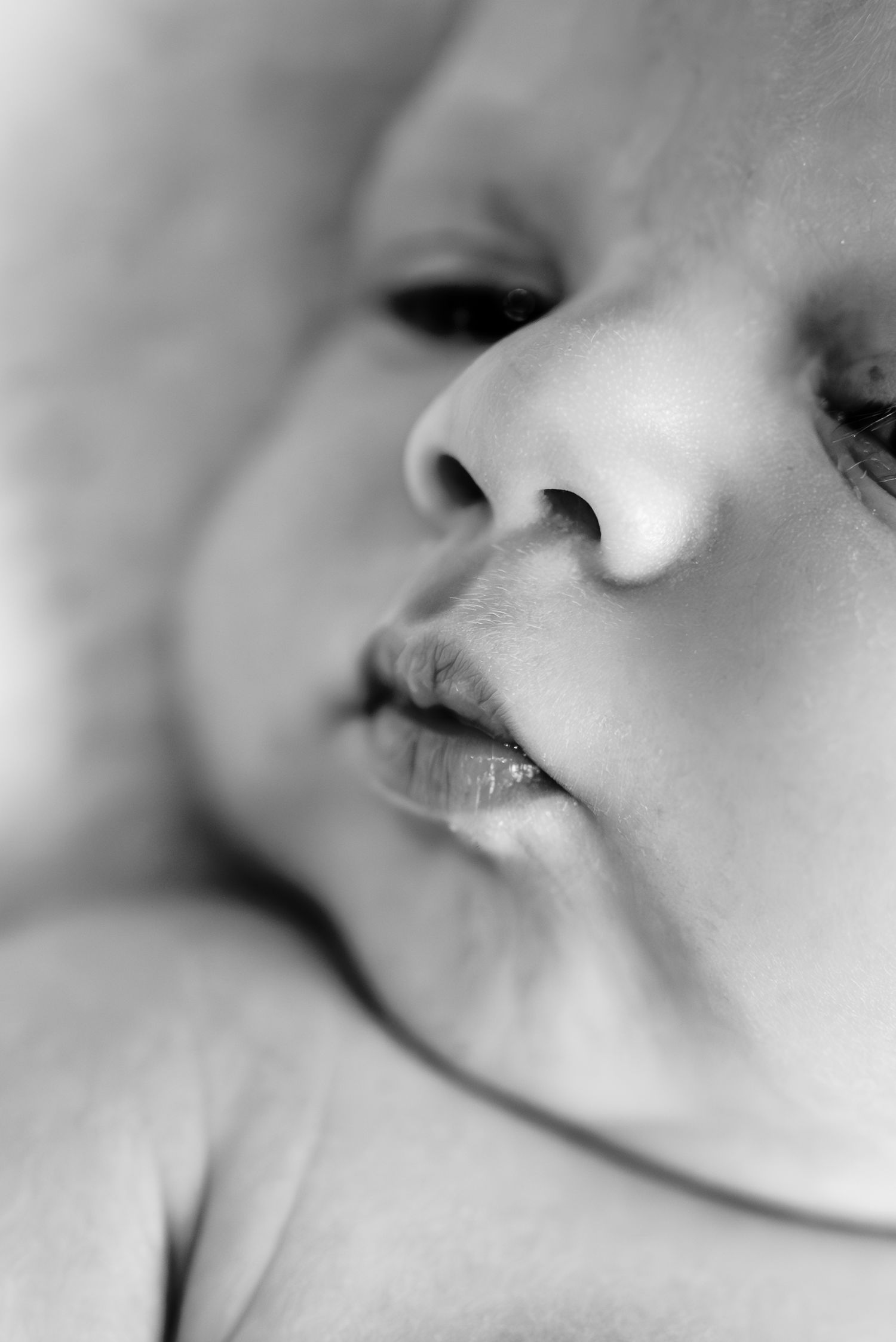 Extreme close-up black and white portrait of baby's facial features.