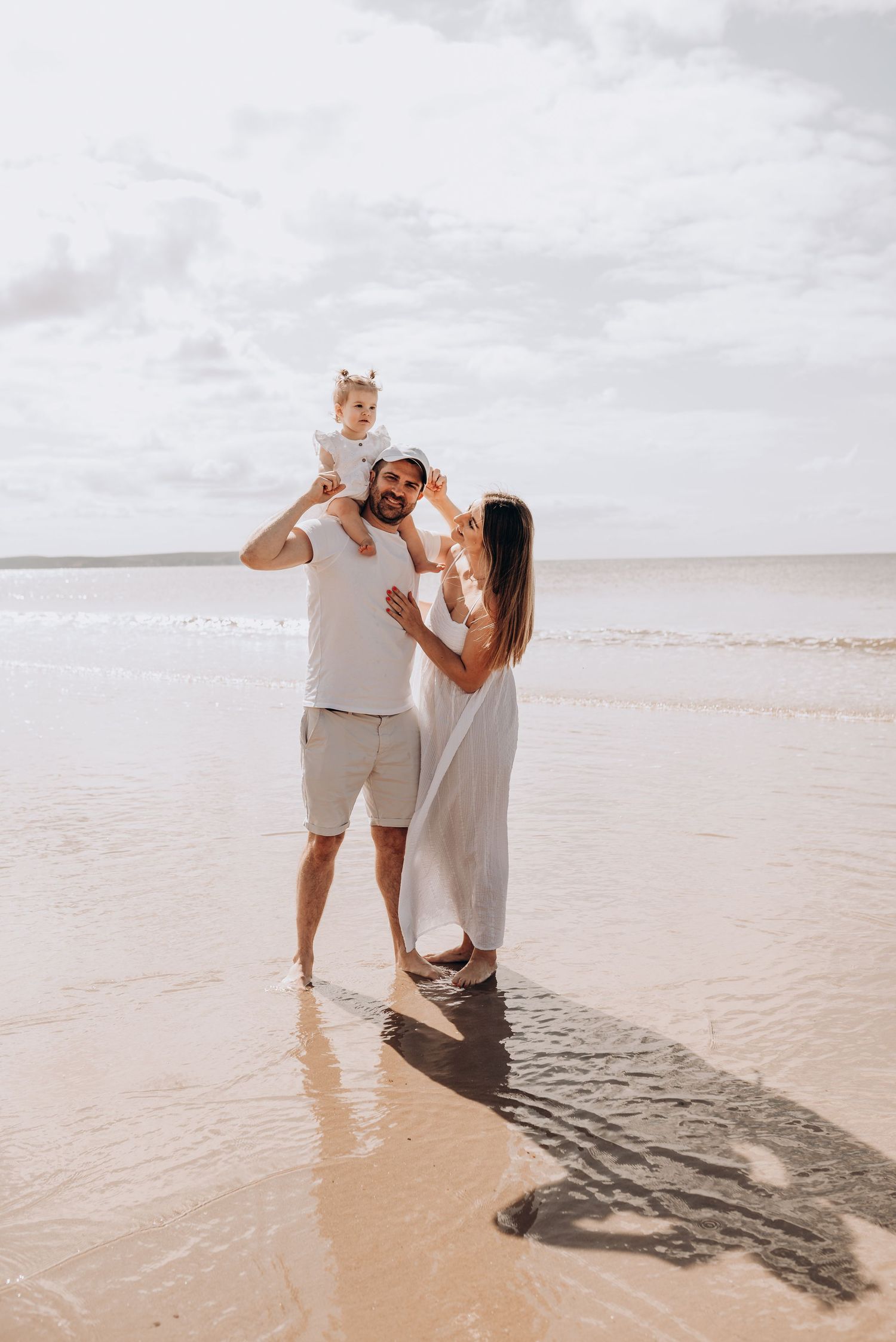 Joyful couple playing and splashing in shallow ocean waters.