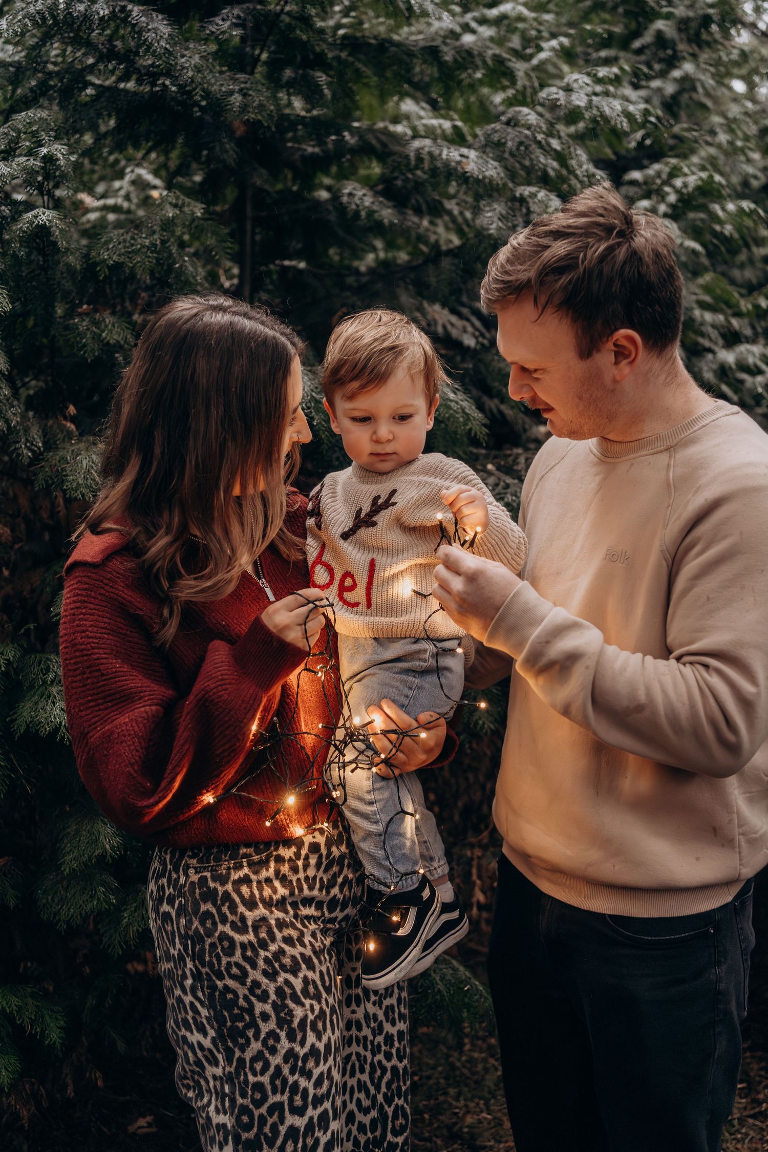 A family shares tender moments together while playing with sparklers in a series of candid outdoor photos.