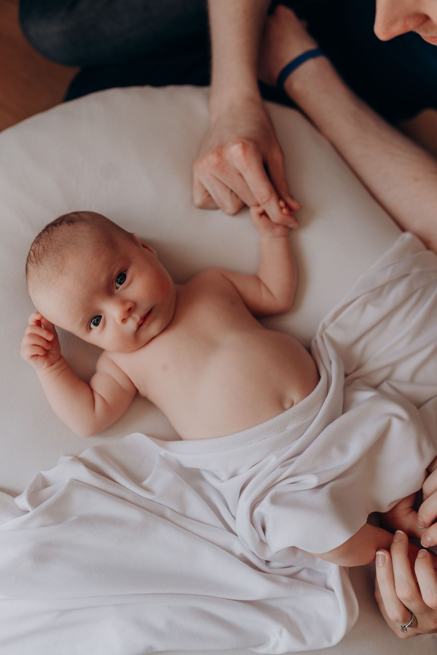 Close-up view of a sleeping baby wrapped in soft white bedding.