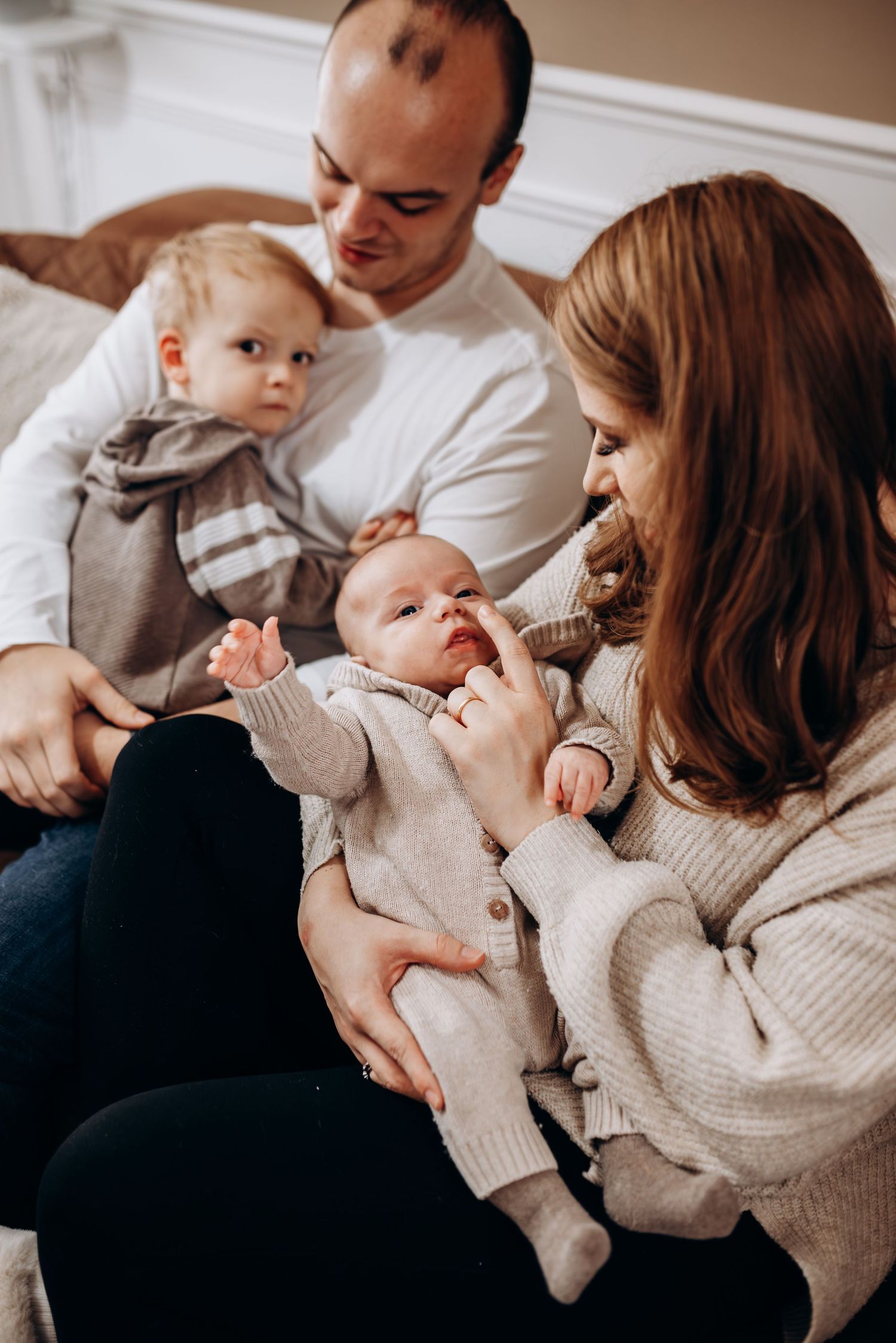 A cozy indoor family moment with soft sweaters and gentle interactions.