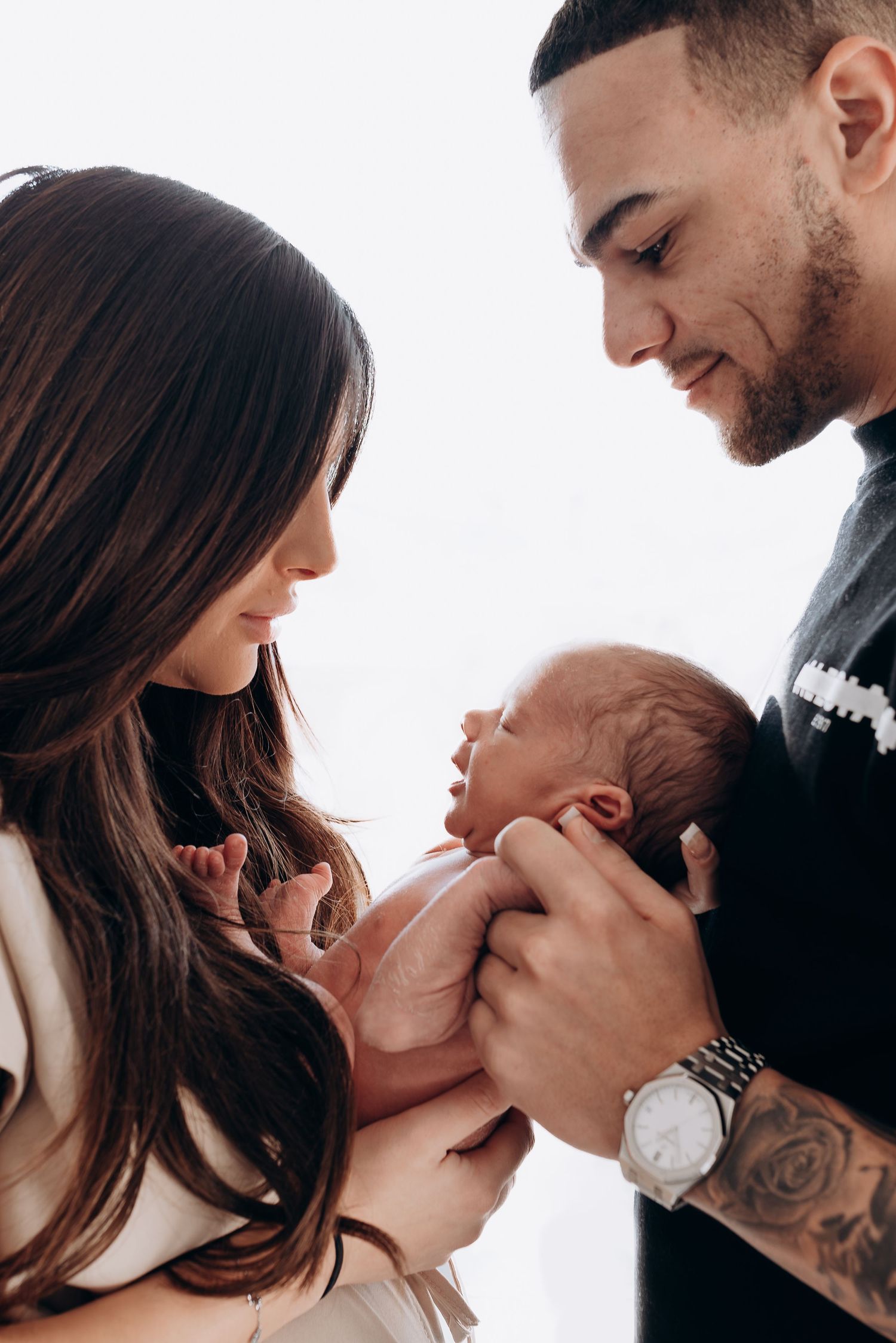 Intimate black and white series of parents sharing tender moments with their newborn.