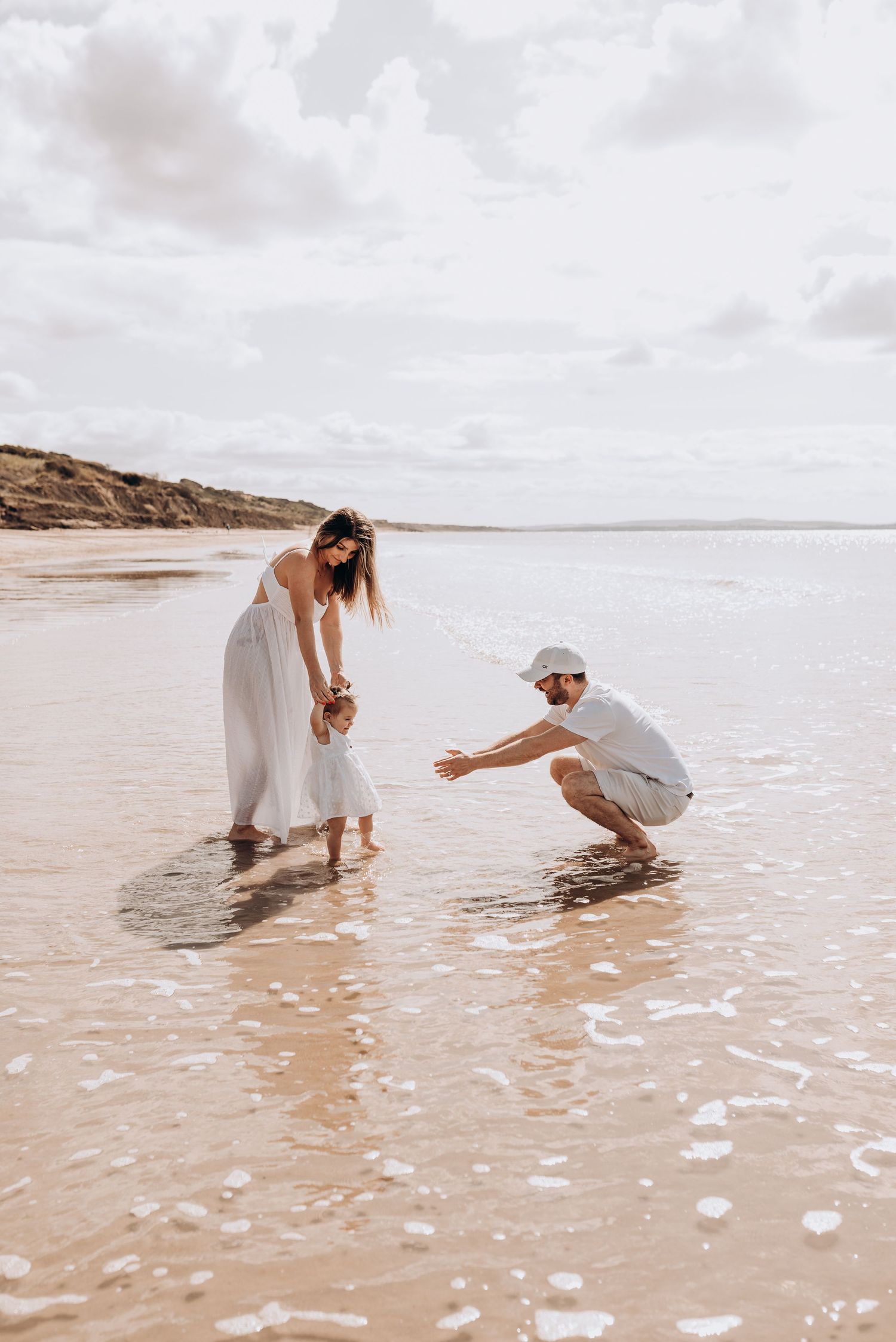 People playing together in the shallow surf at a scenic beach.