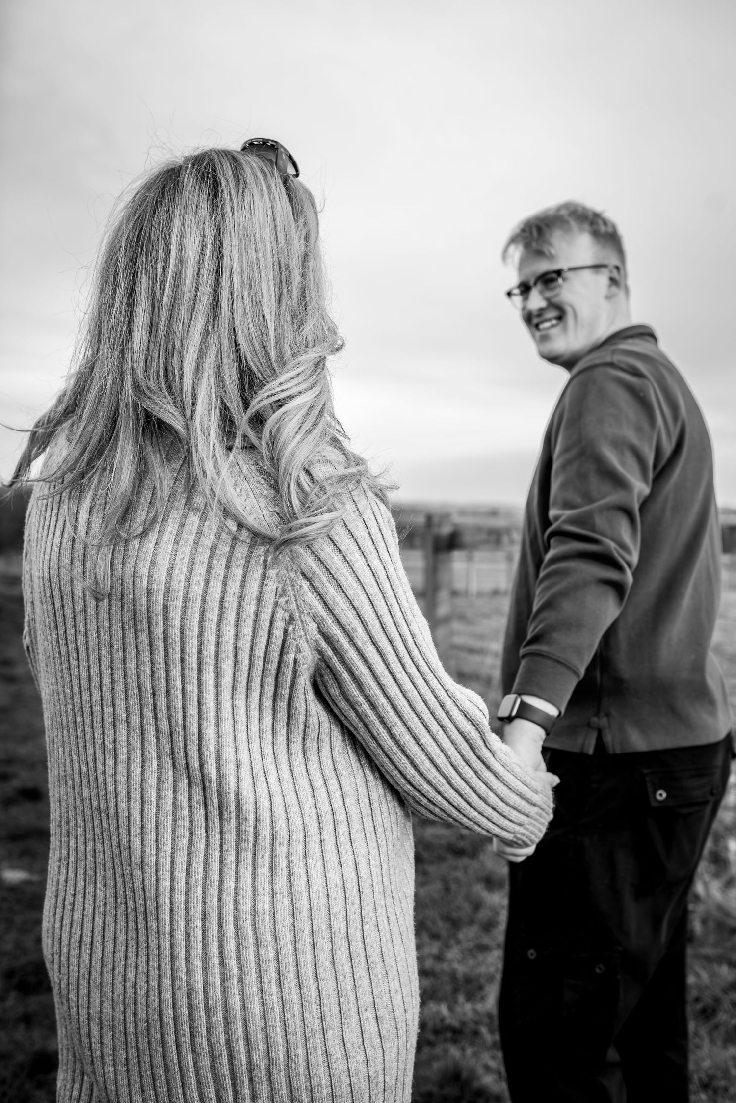 A black and white maternity photoshoot outdoors in winter clothing.