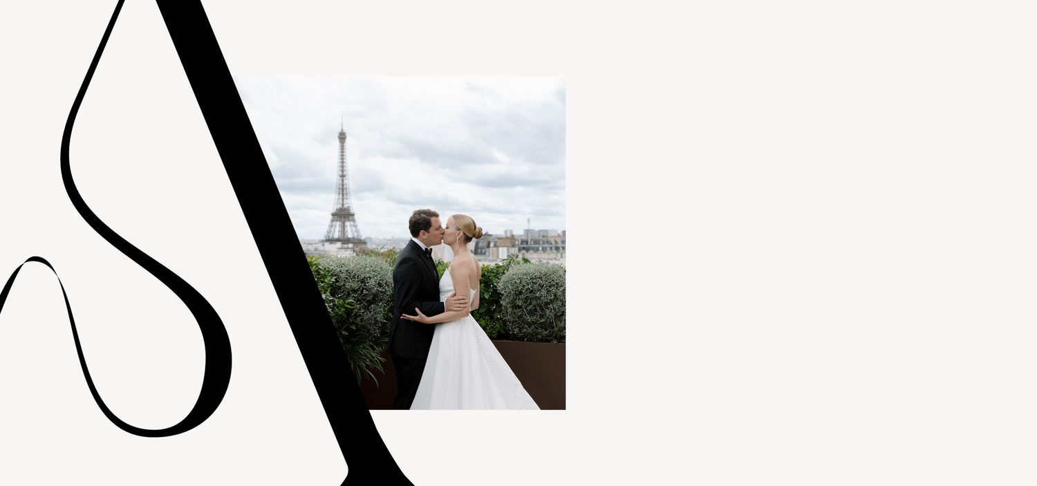Romantic wedding photo with Eiffel Tower visible in background against cloudy Paris sky.