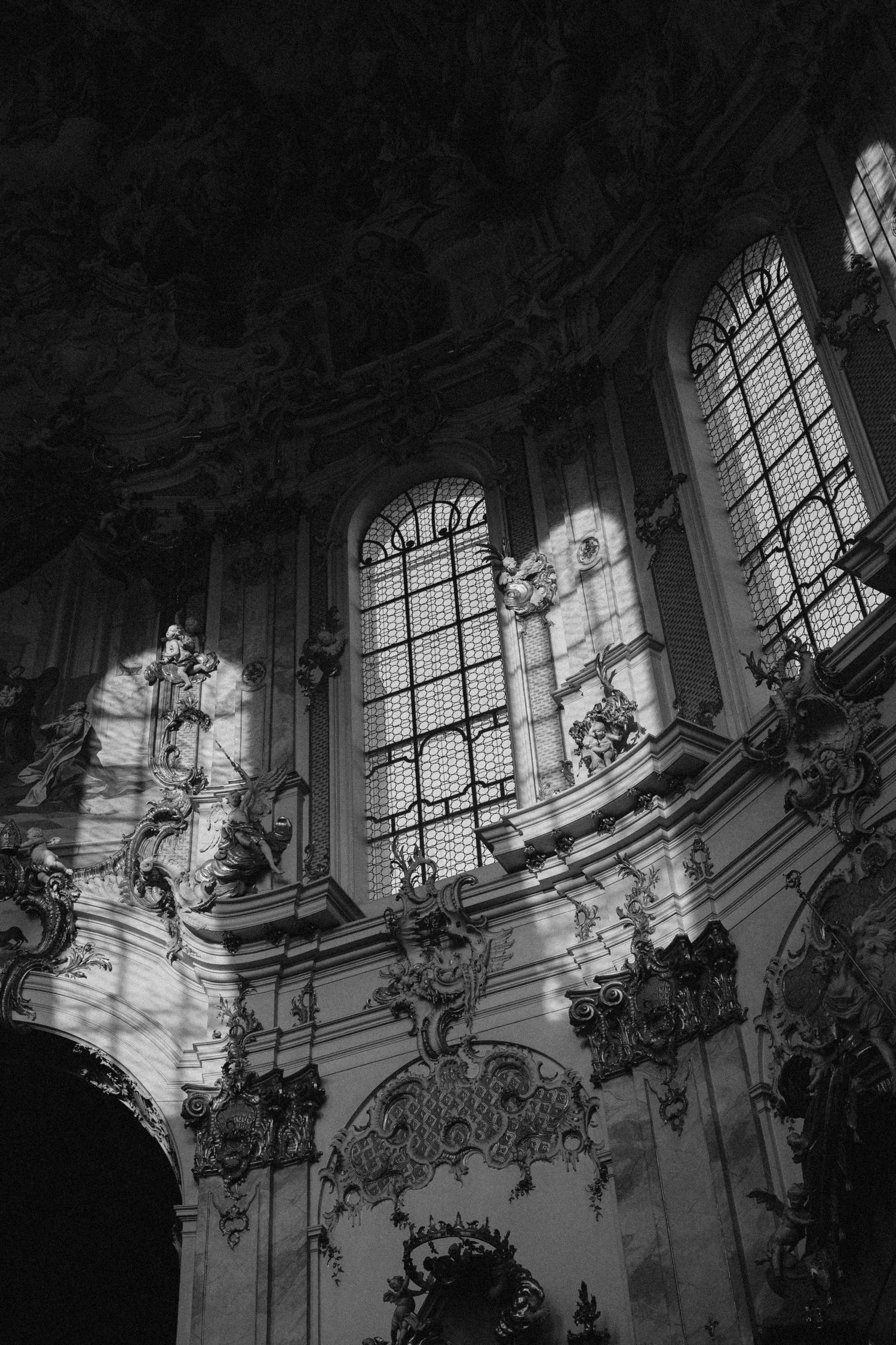 Sunlight streams through ornate gothic windows in historic church interior.