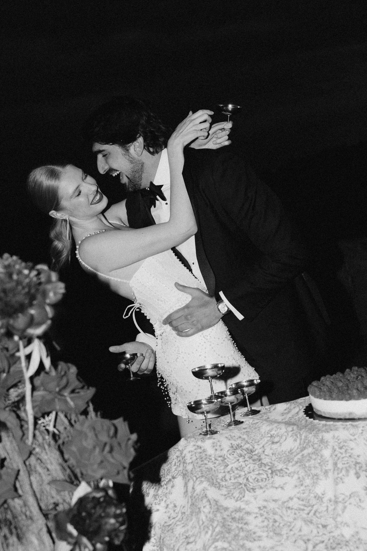 Black and white photo of a romantic dance dip at a wedding celebration.