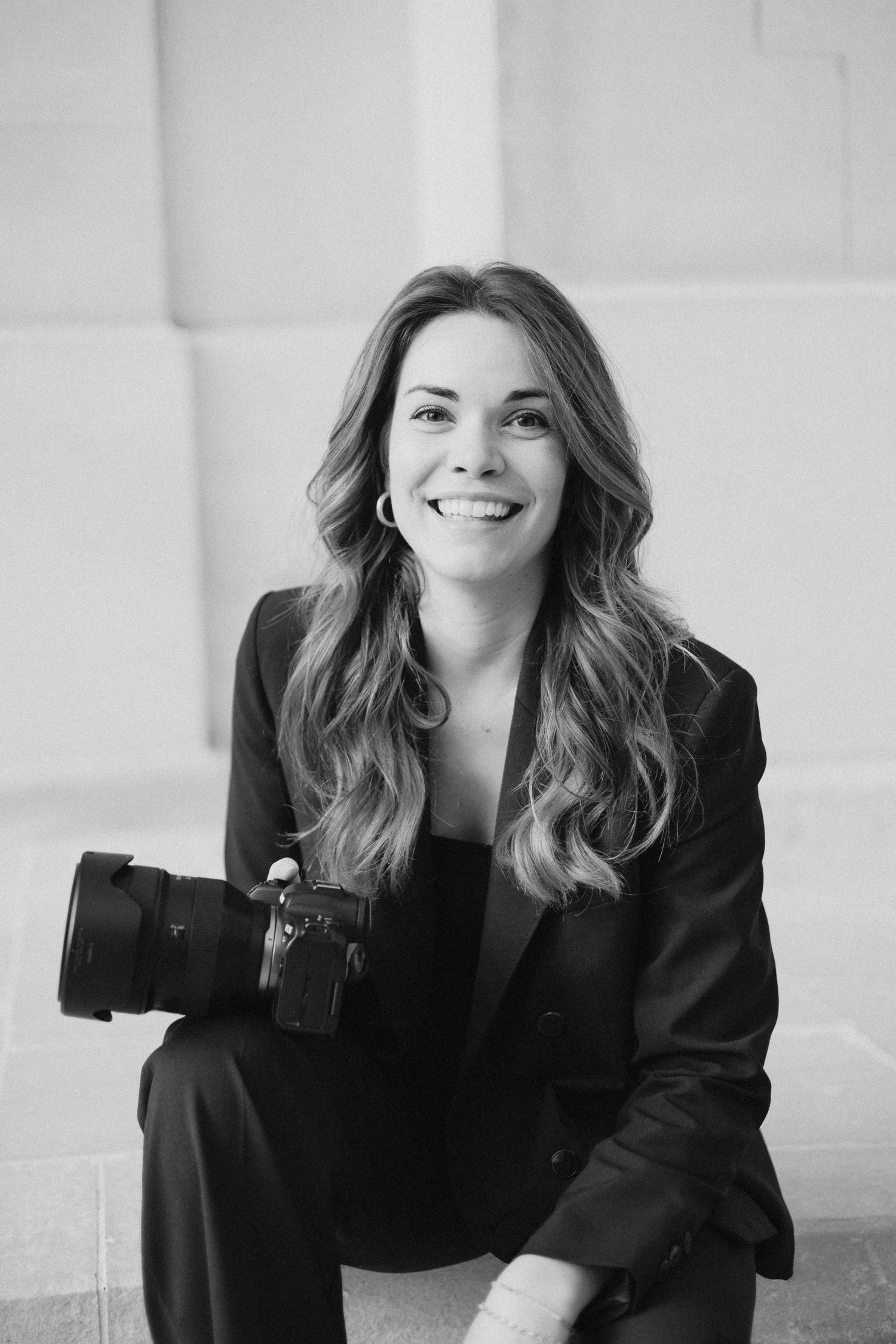 Professional headshots showing joyful expressions in black and white against light background.