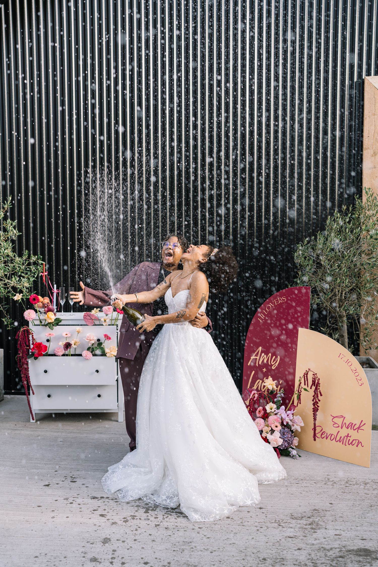 A bride in a white wedding dress throws glitter in front of a striped wall in a series of sequential photos.