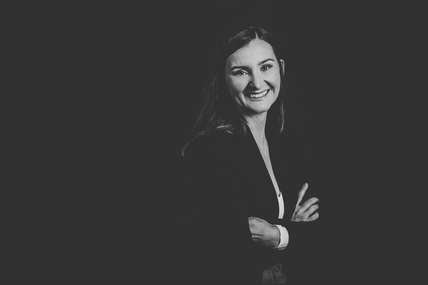 black and white portrait of Andrea Collins Photography with arms gently folded and a natural smile.