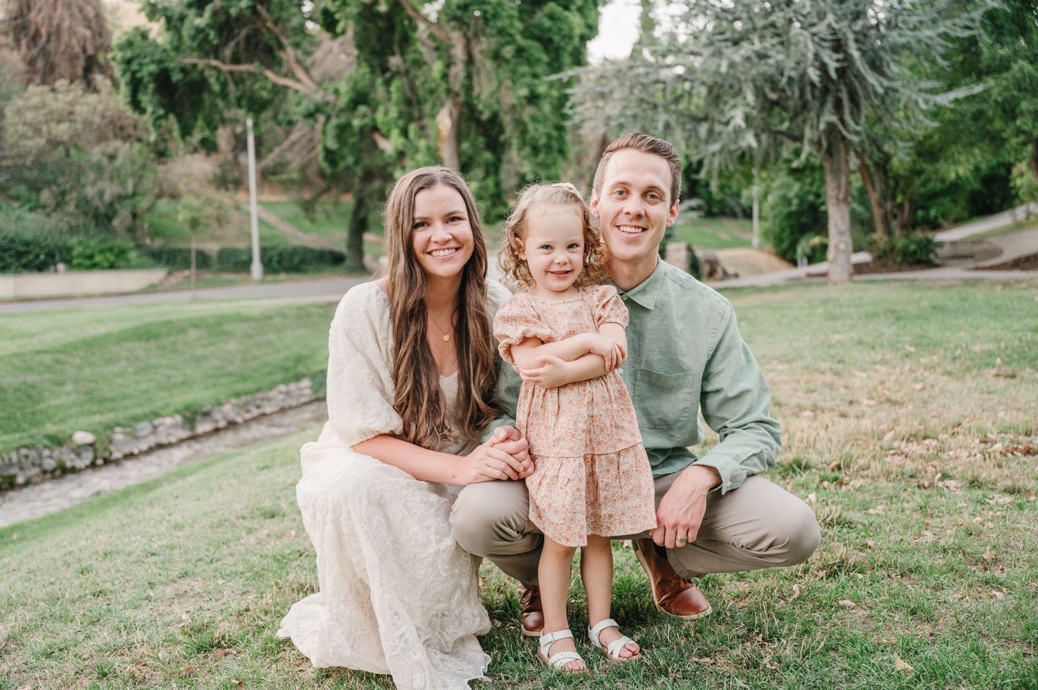 Small family portrait in a peaceful garden setting with natural greenery.