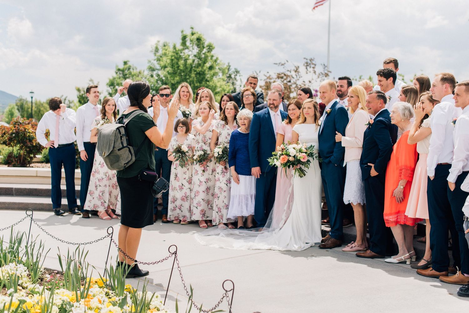 Wedding guests gathered outdoors for a group photo during a ceremony.