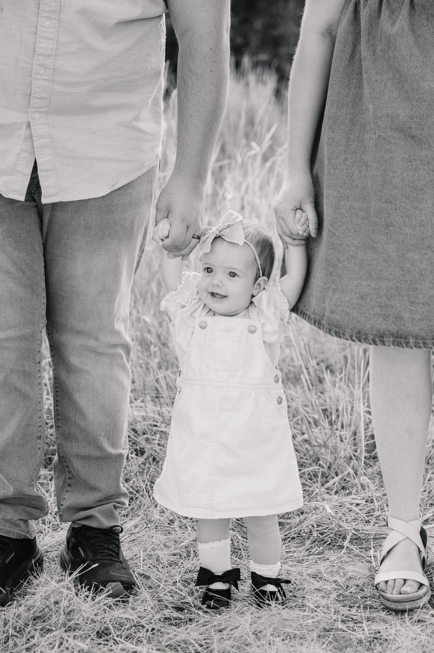 Black and white photo showing feet of people standing in grass at a casual outdoor gathering.