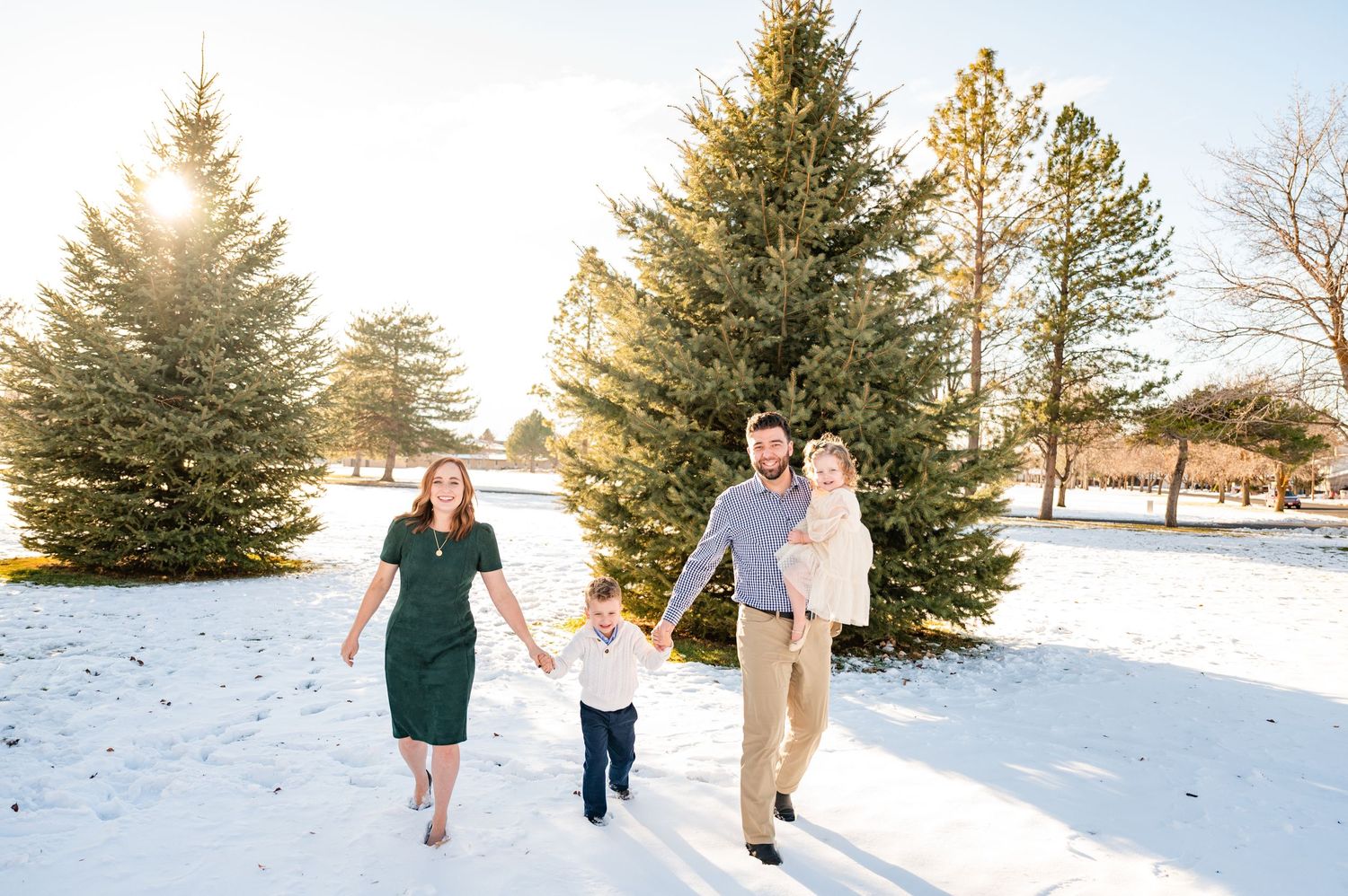 A family walking together through a snowy landscape during golden hour.