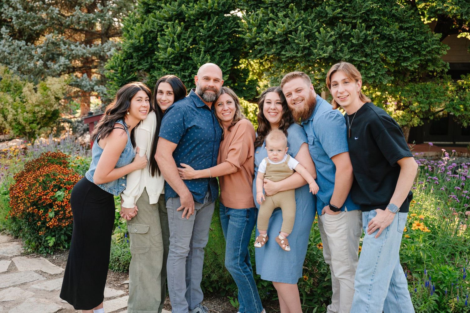 A casual group photo of people gathered together in a garden setting.