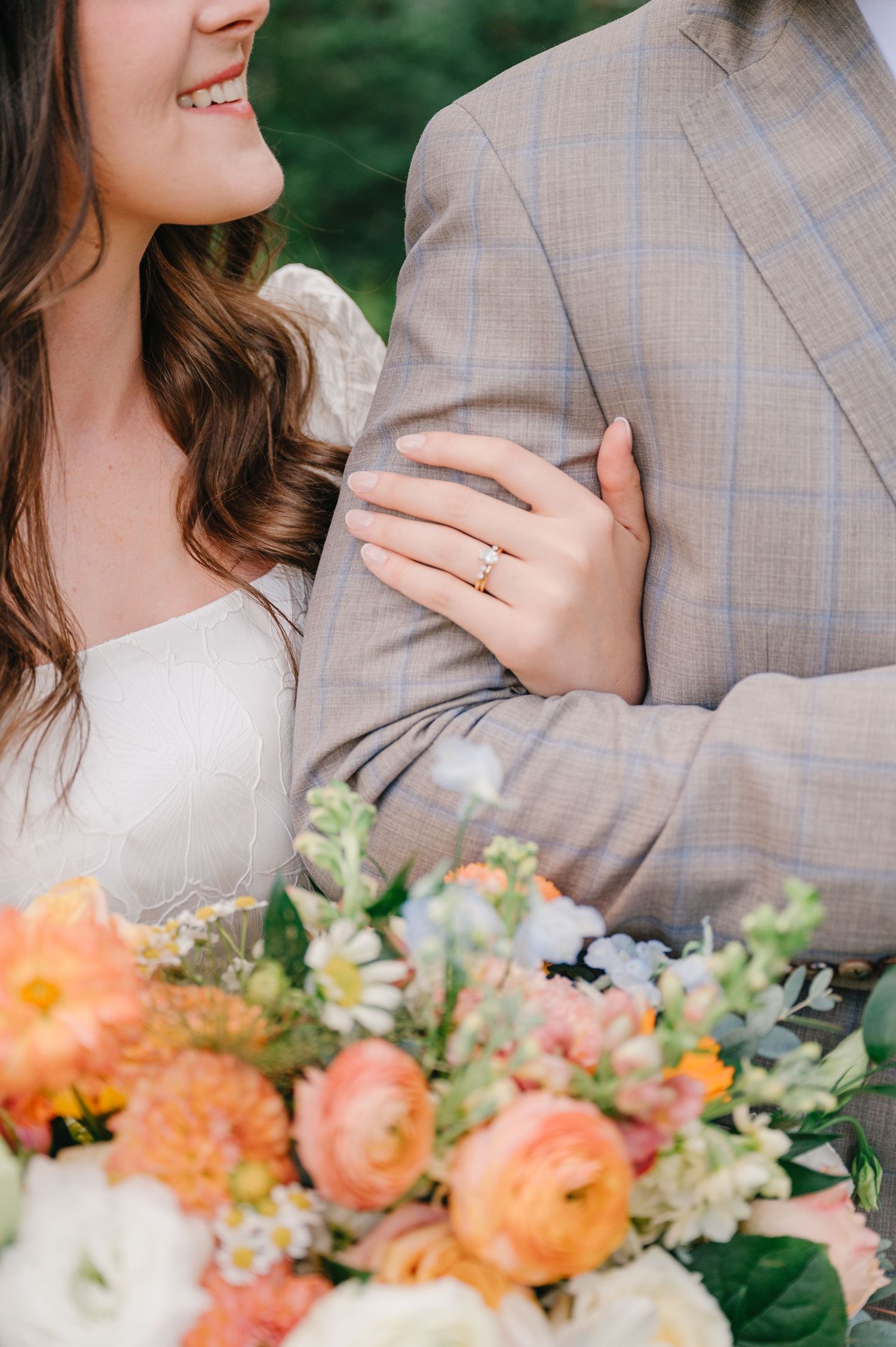 A romantic wedding moment captured with a peach and white floral bouquet in the foreground.