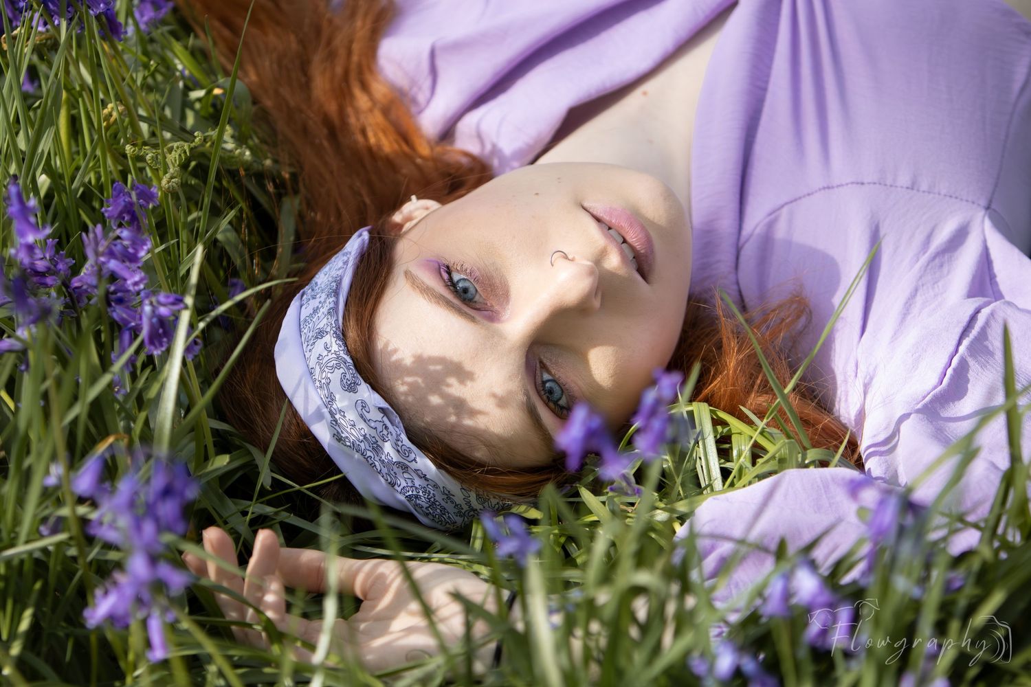 Mini shooting jacinthes – femme rousse allongée dans les fleurs violettes sauvages en pleine forêt