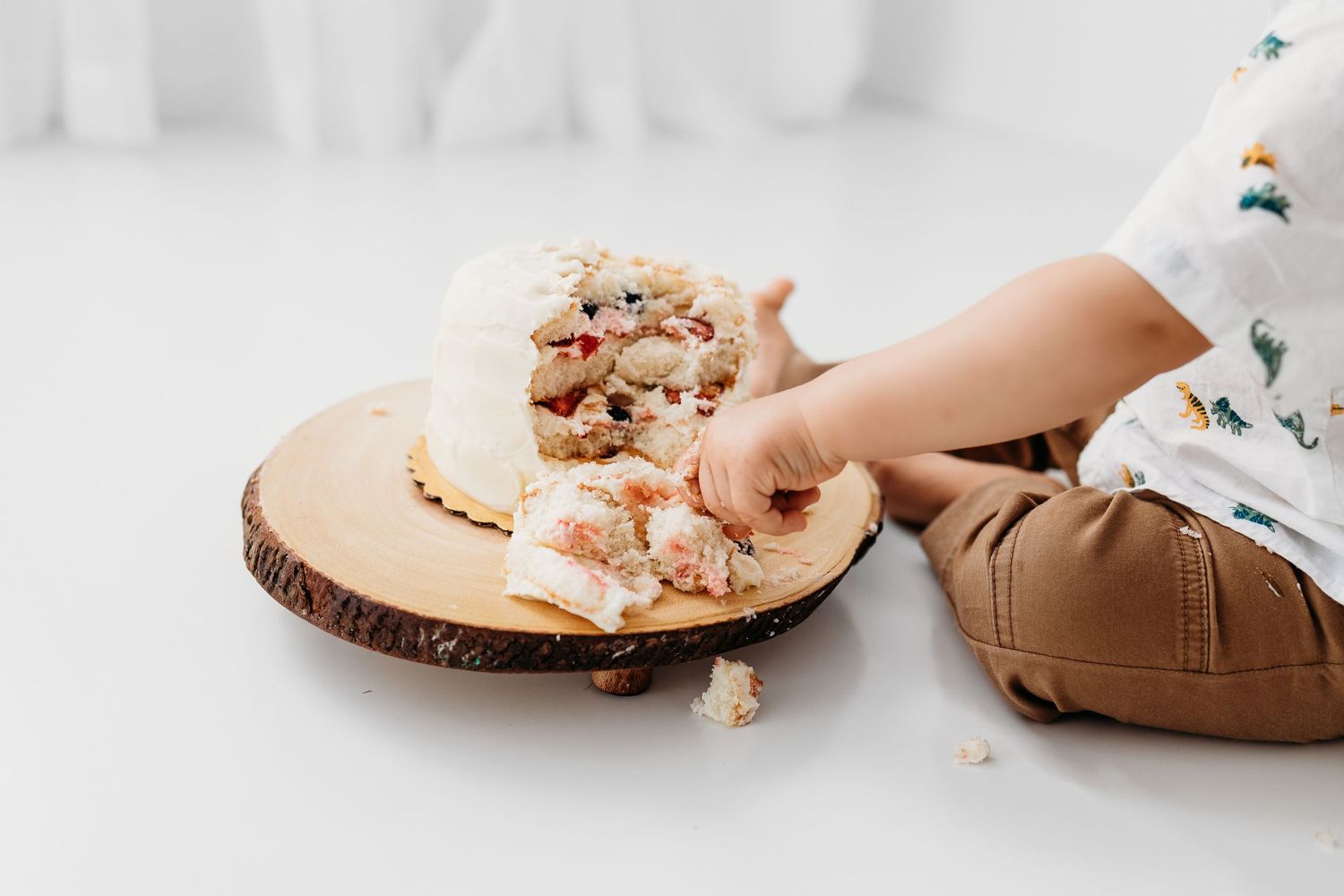 Close up of little tiny hands poking his birthday cake during 1st birthday photo session by Santa Fe photographer. From 