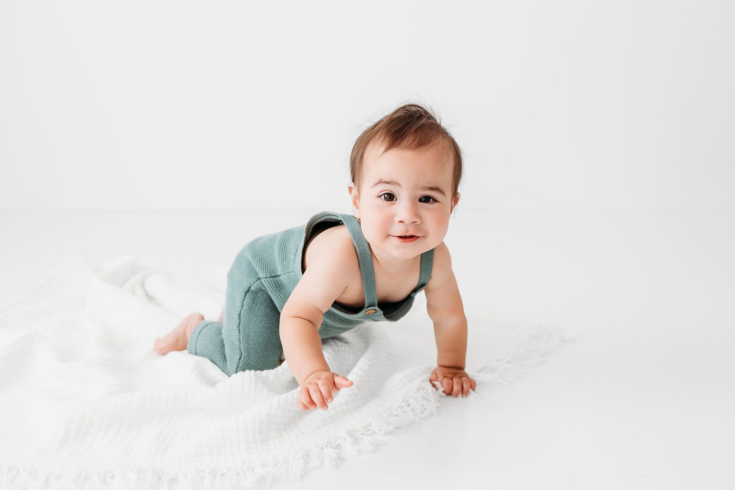 Cute little boy crawling during his 1st birthday photography session in Santa Fe. Baby at his cake smash by Santa Fe pho