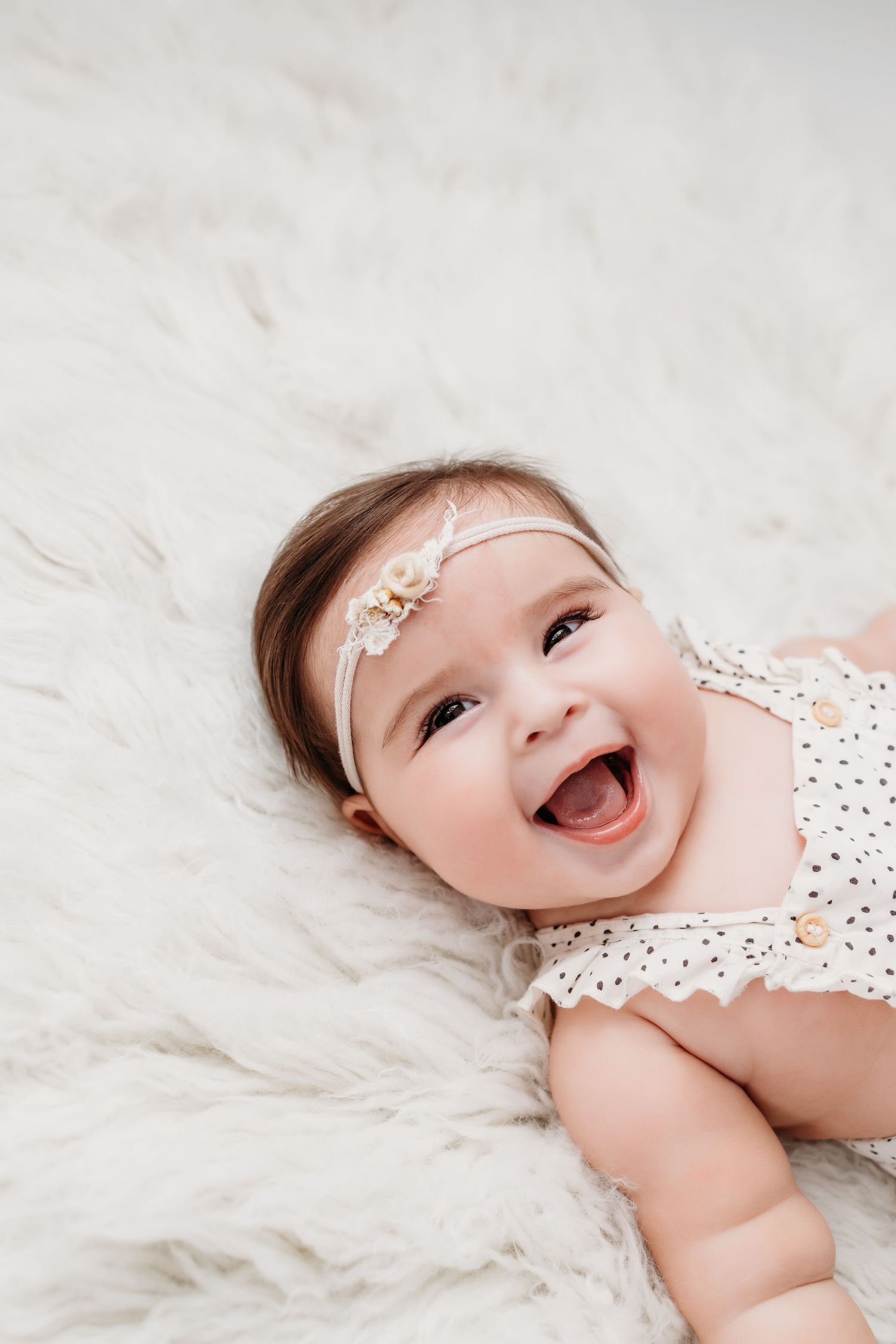 Image of cute 6 month old baby smiling during her milestone photography session. Photos by Santa Fe baby photographer in