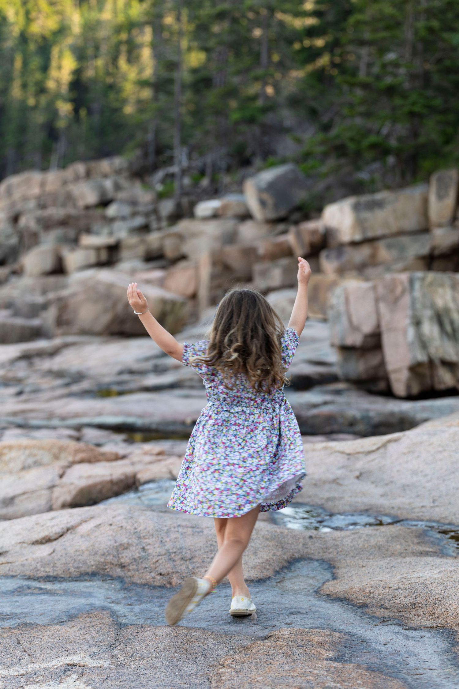 A child dancing during a family portrait session in Acadia NP