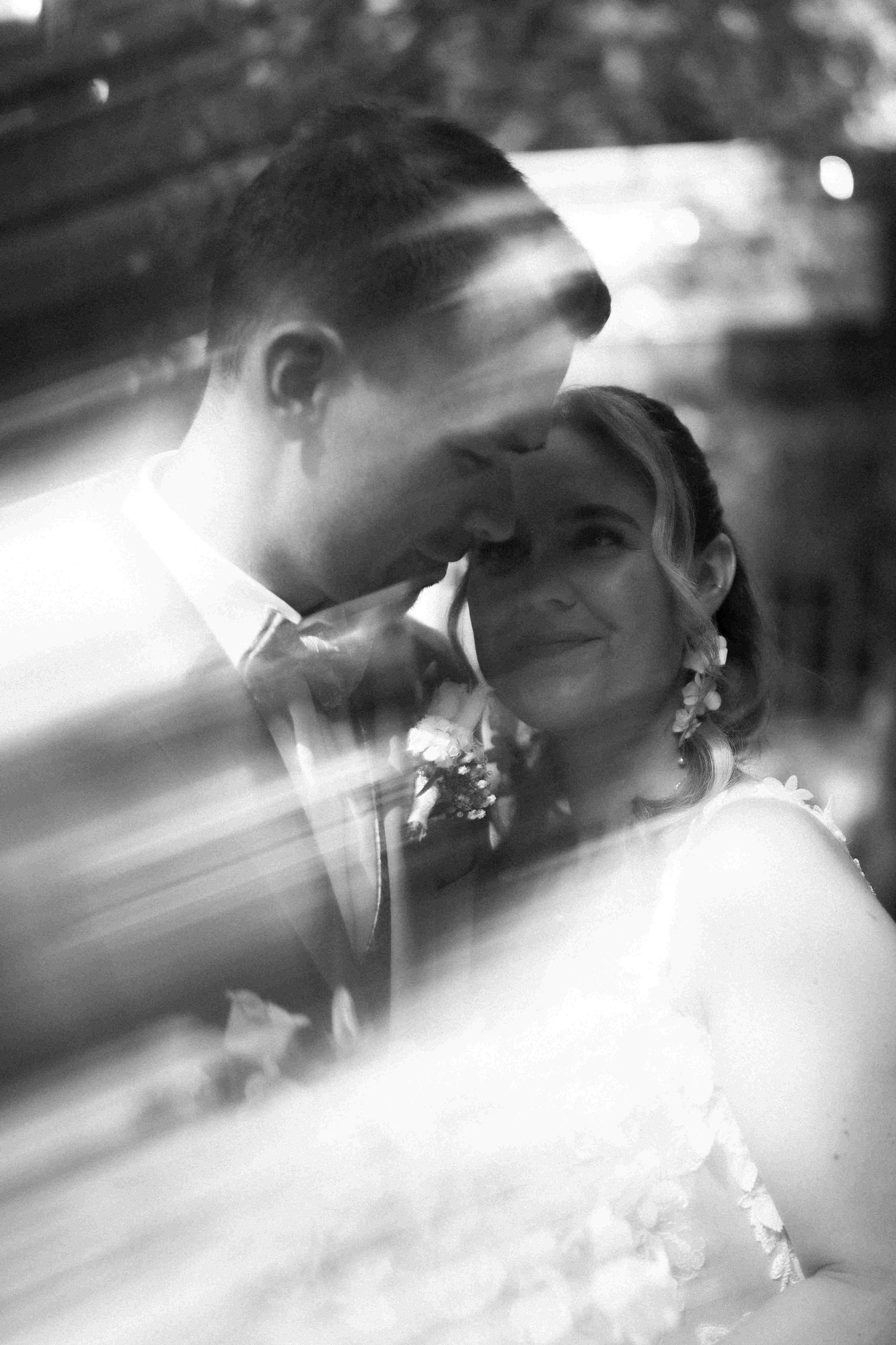 Intimate black and white portrait of newlyweds with dramatic lighting.