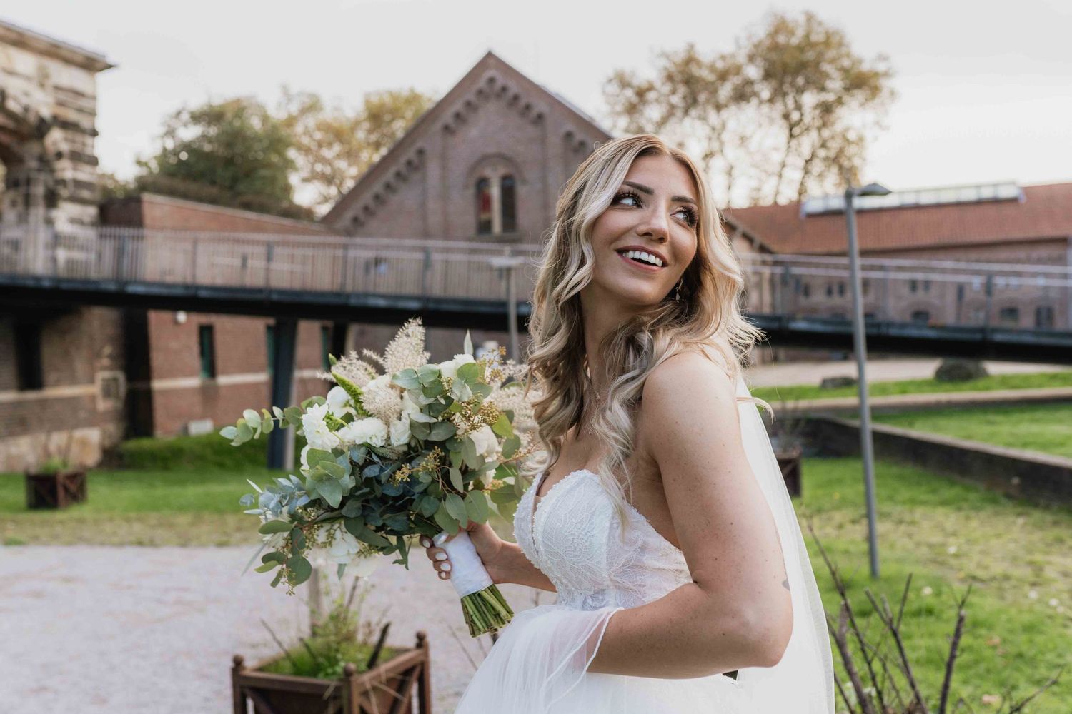 A happy bride twirls in her white wedding gown against a backdrop of historic buildings.