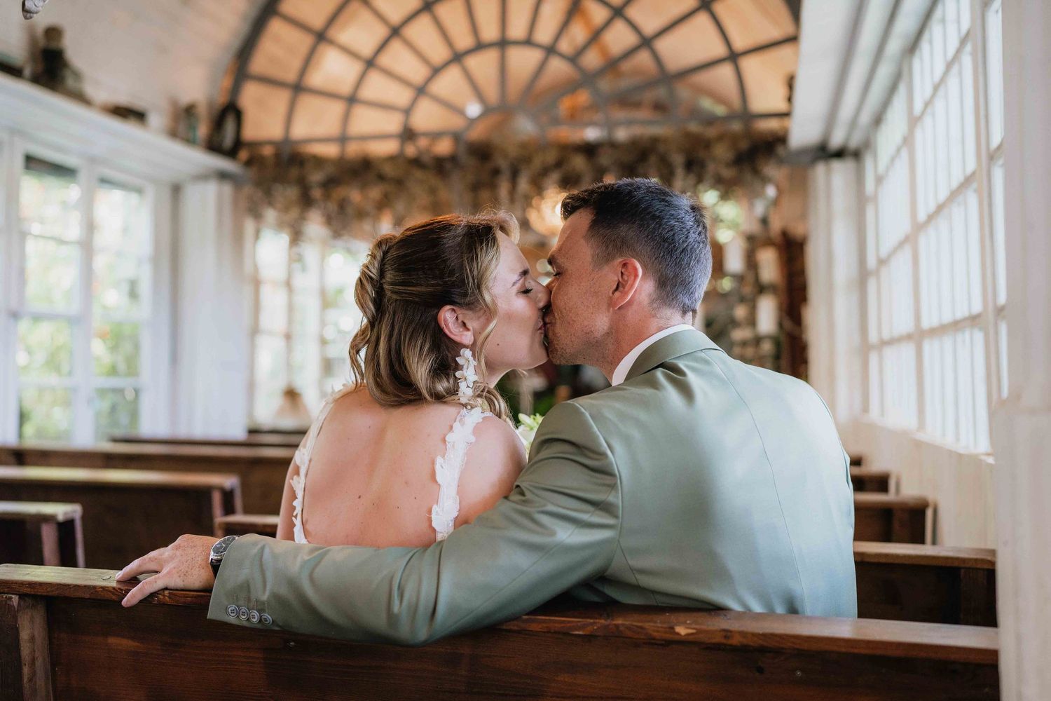 A romantic moment captured in soft lighting inside an elegant church wedding venue.