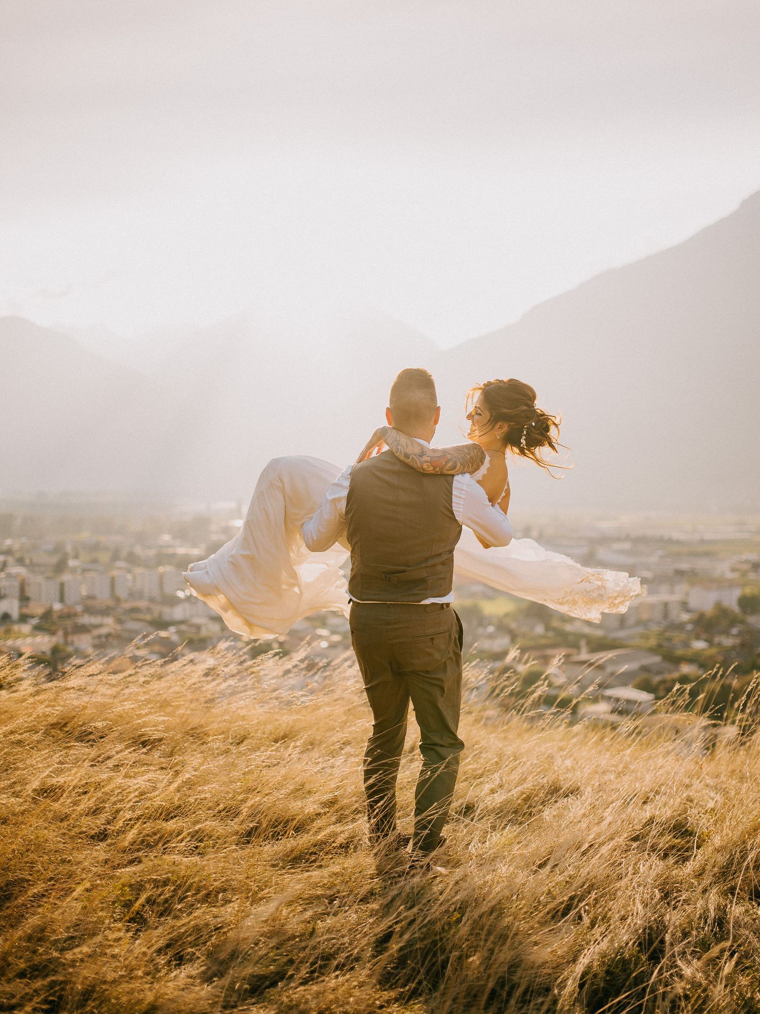 Silhouettes dance together on a hilltop overlooking a cityscape during golden hour.