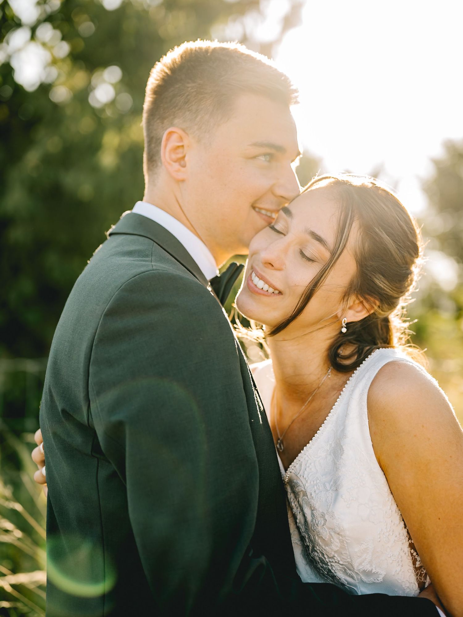 A romantic wedding couple shares intimate moments at sunset with golden bokeh in the background.