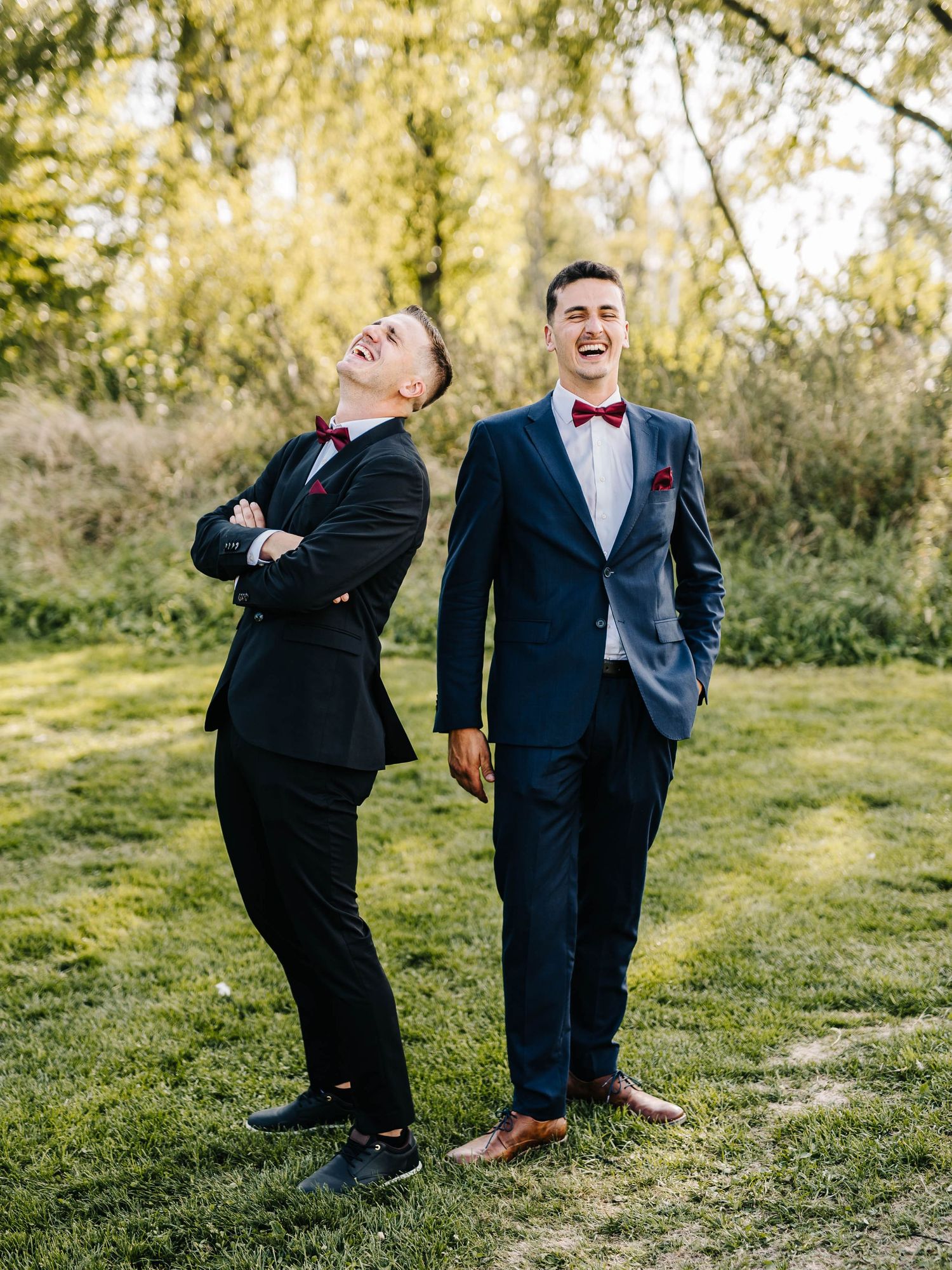 Playful wedding party poses on grassy hillside.