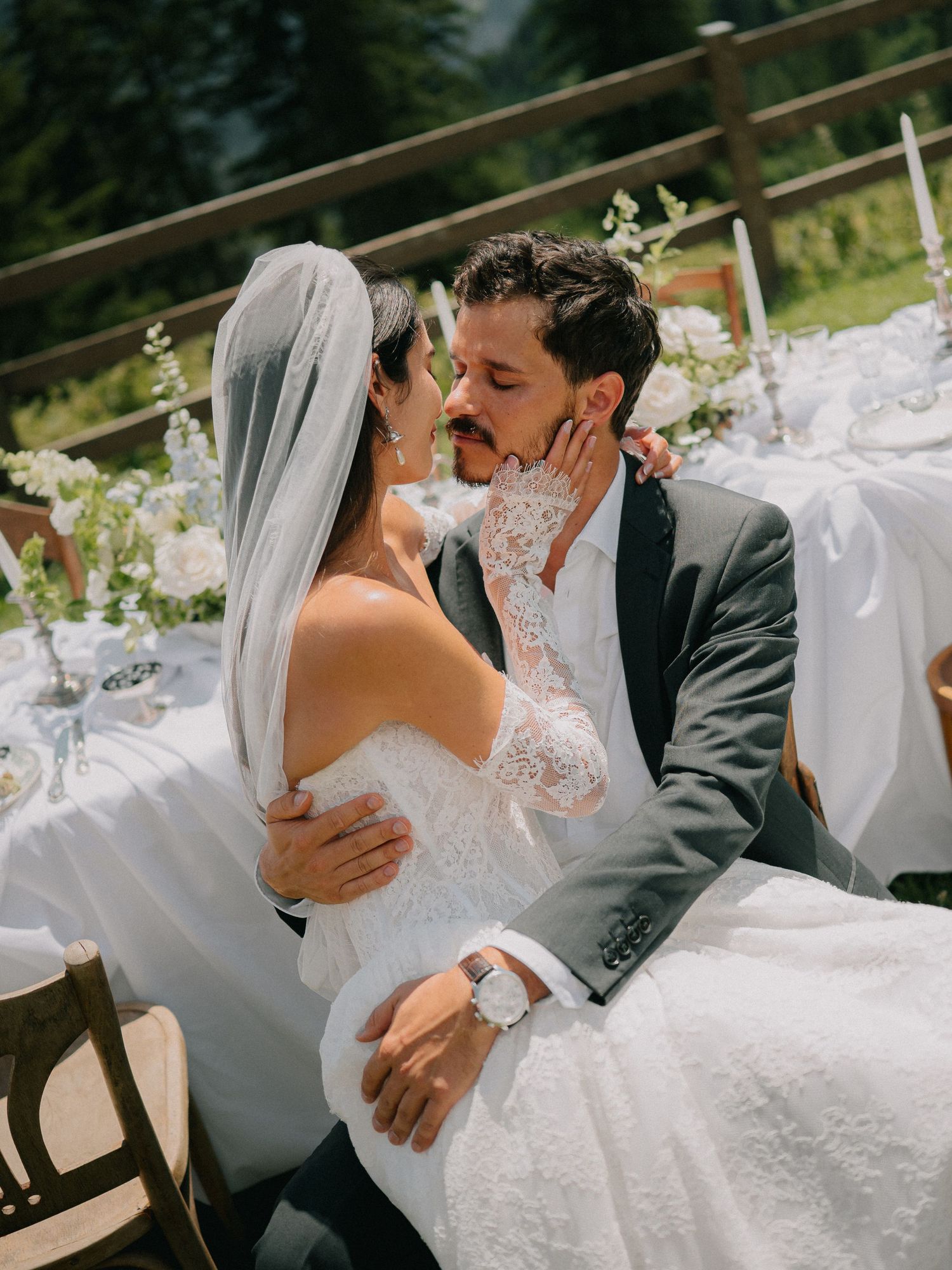A romantic wedding couple shares intimate kisses in a series of candid outdoor photos with white decor.