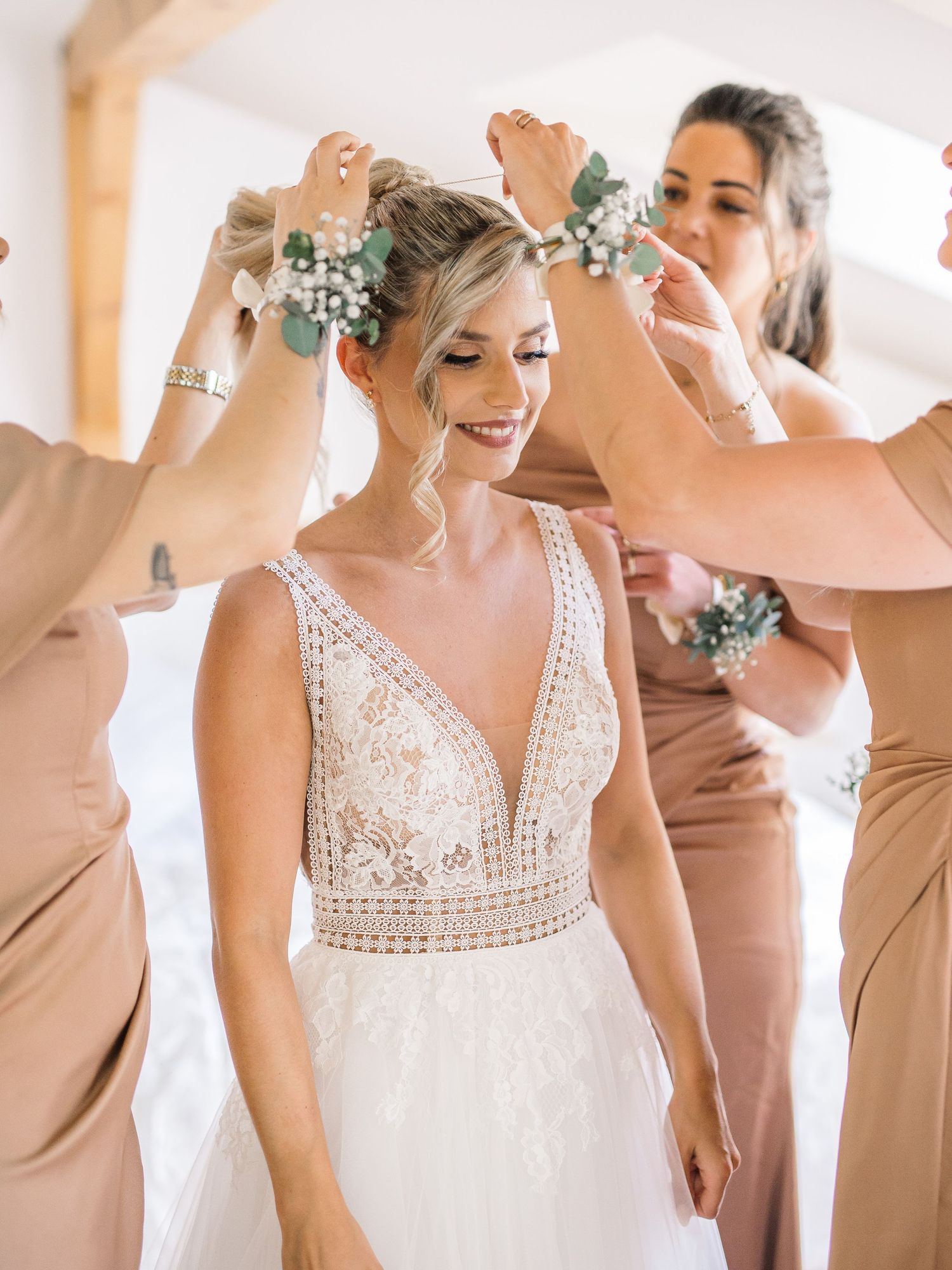 Wedding party preparations showing detailed lace dress and neutral-toned bridesmaid dresses.
