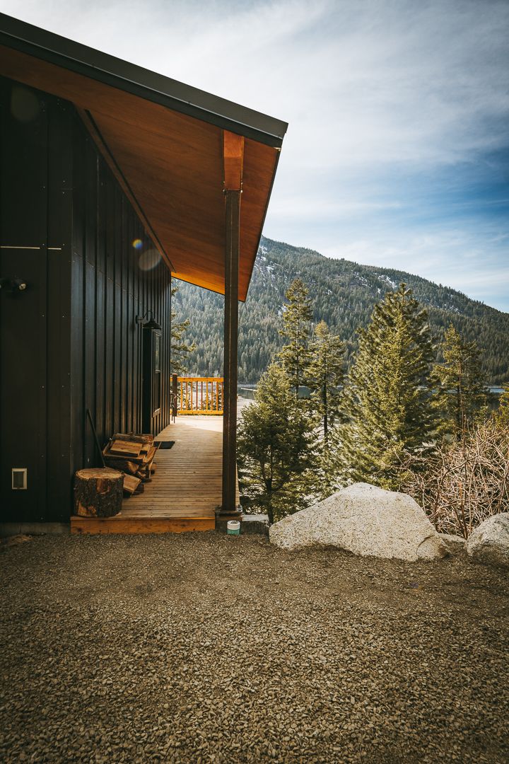 Mountain retreat with covered porch overlooking pine forest and snow-capped peaks.