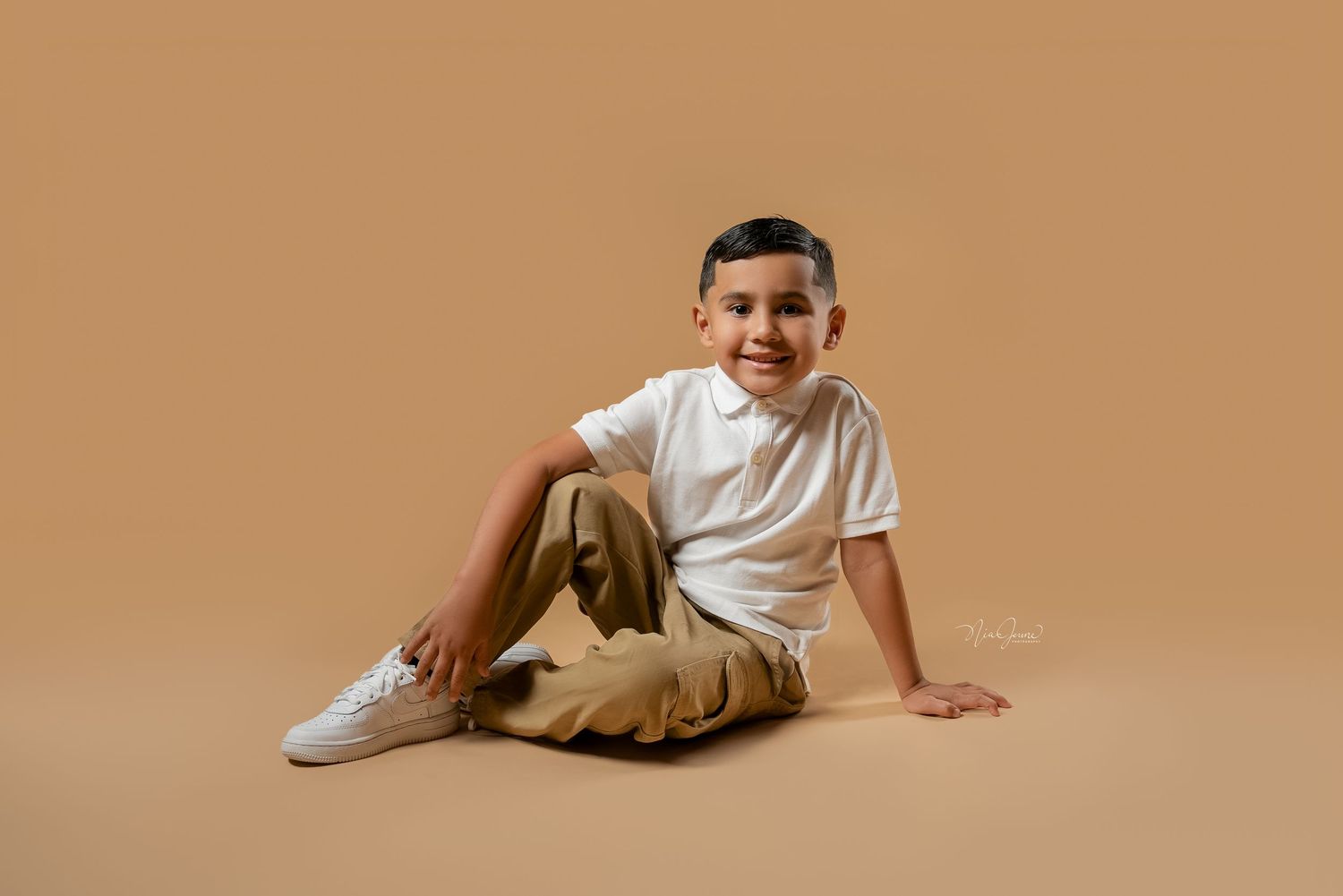 Lifestyle studio portraits of a young child on a brown backdrop.