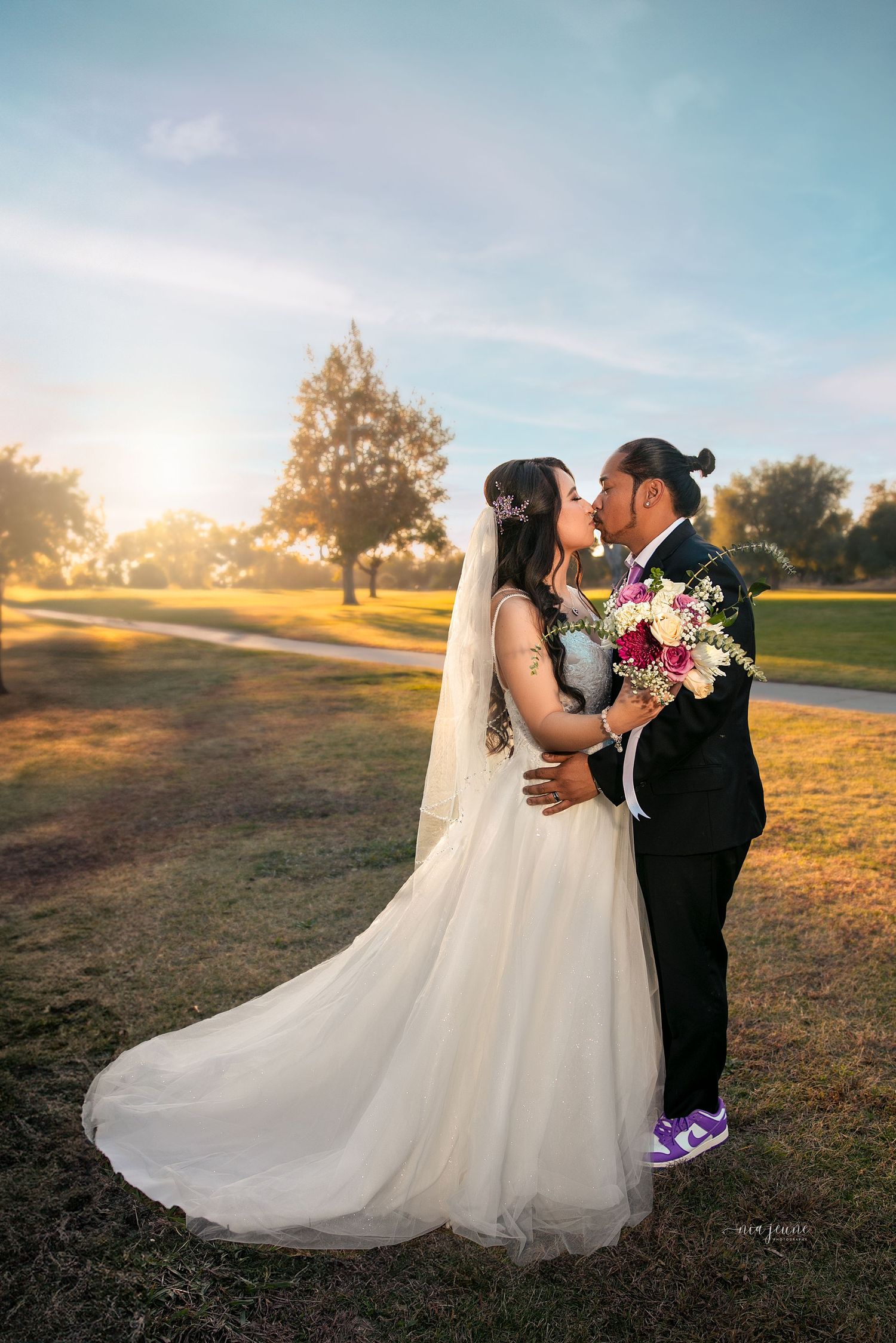 Romantic sunset wedding photos showcase a couple embracing in a golden field.